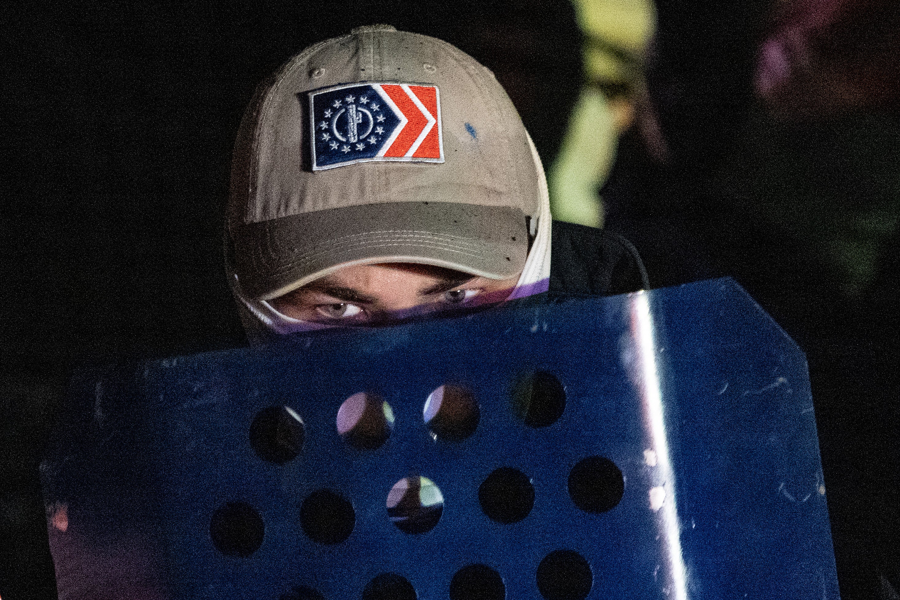 A member of the rightwing group Patriot Front peers over his shield after marching on the National Mall on December 04, 2021 in Arlington, Virginia