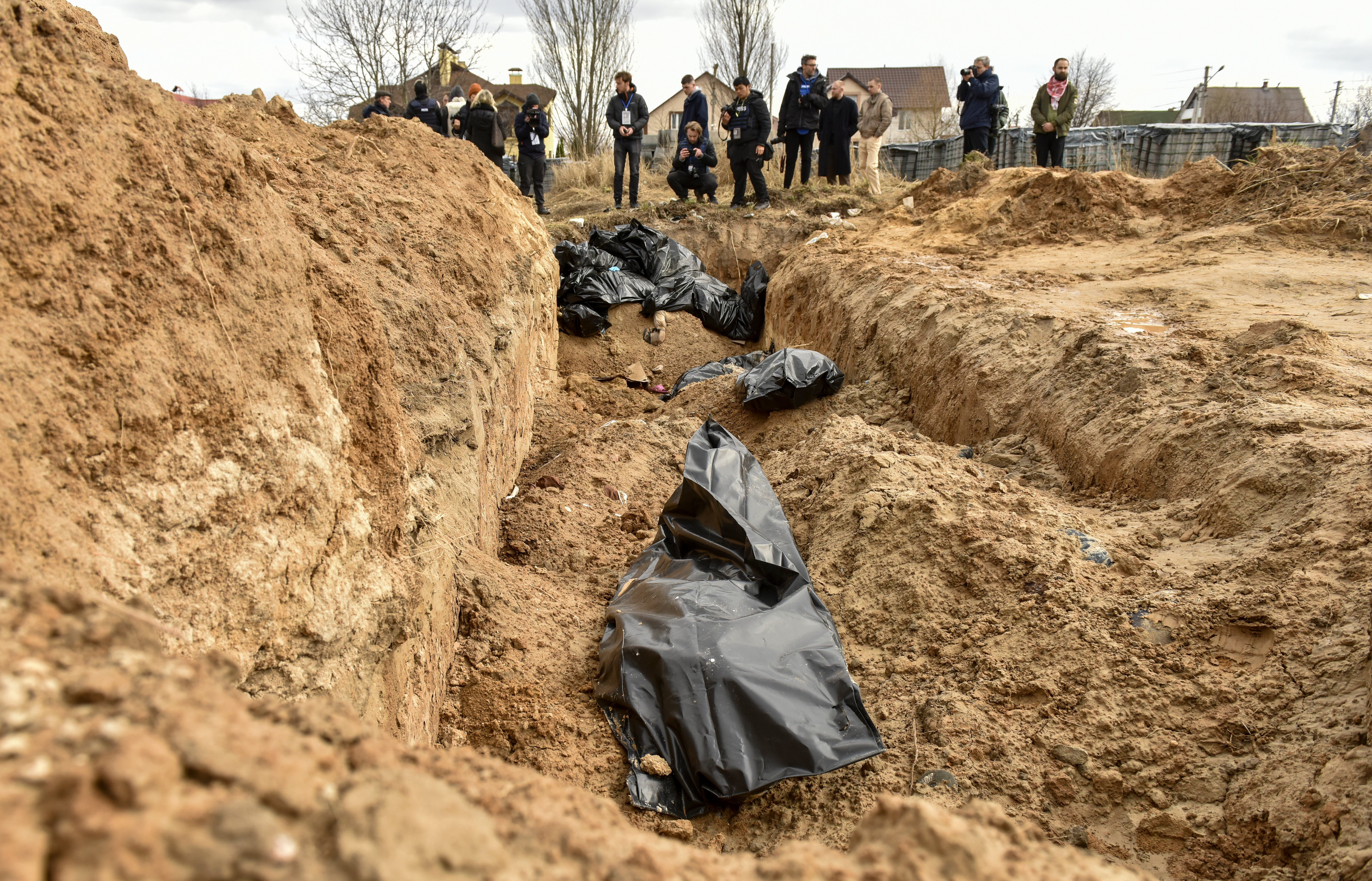 Bodies of civilians in plastic bags lay in a mass grave in Bucha, recently recaptured by the Ukrainian army