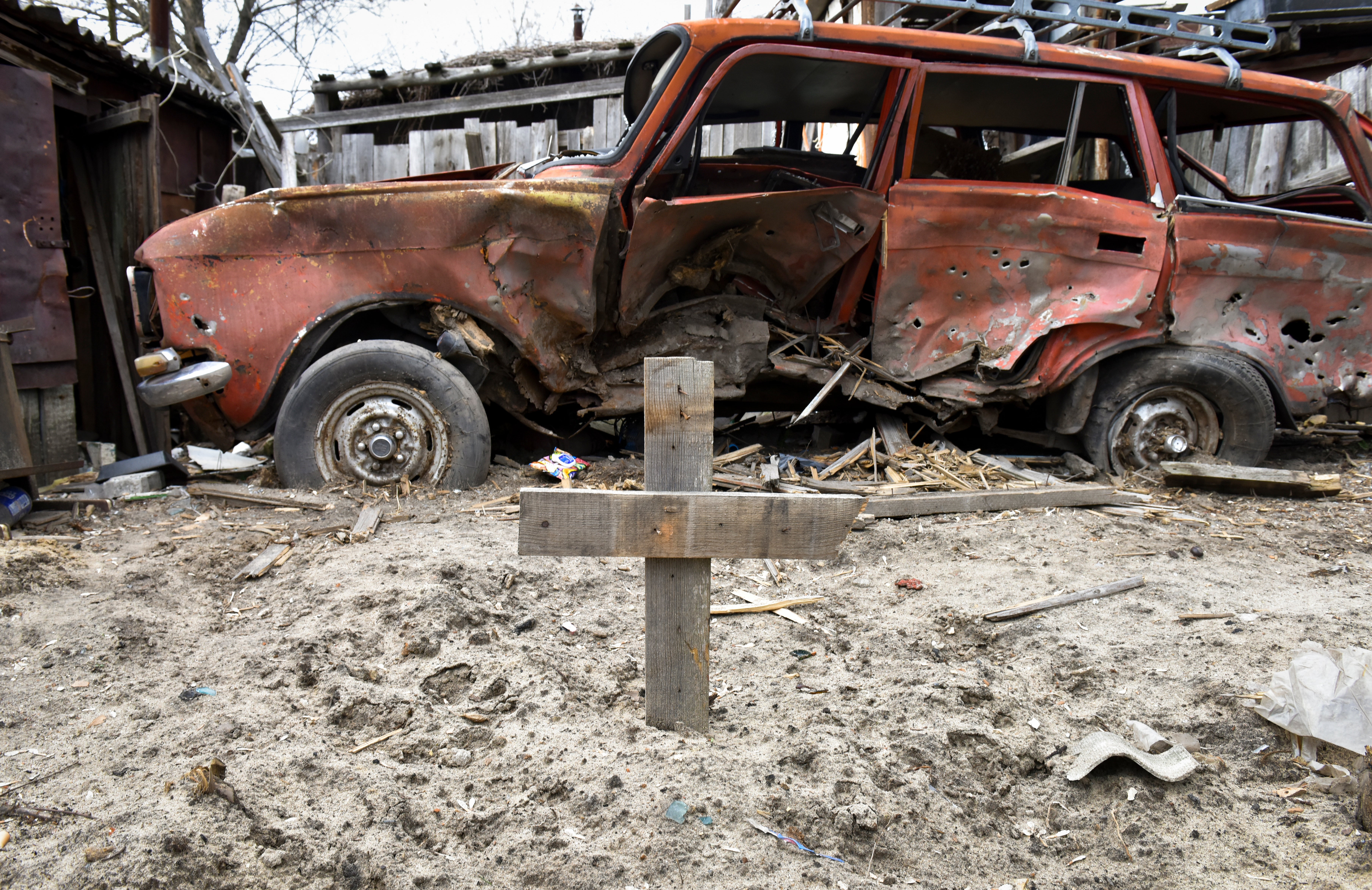 A grave is marked with a cross in the backyard of a house in Hostomel near Kyiv, 6 April 2022