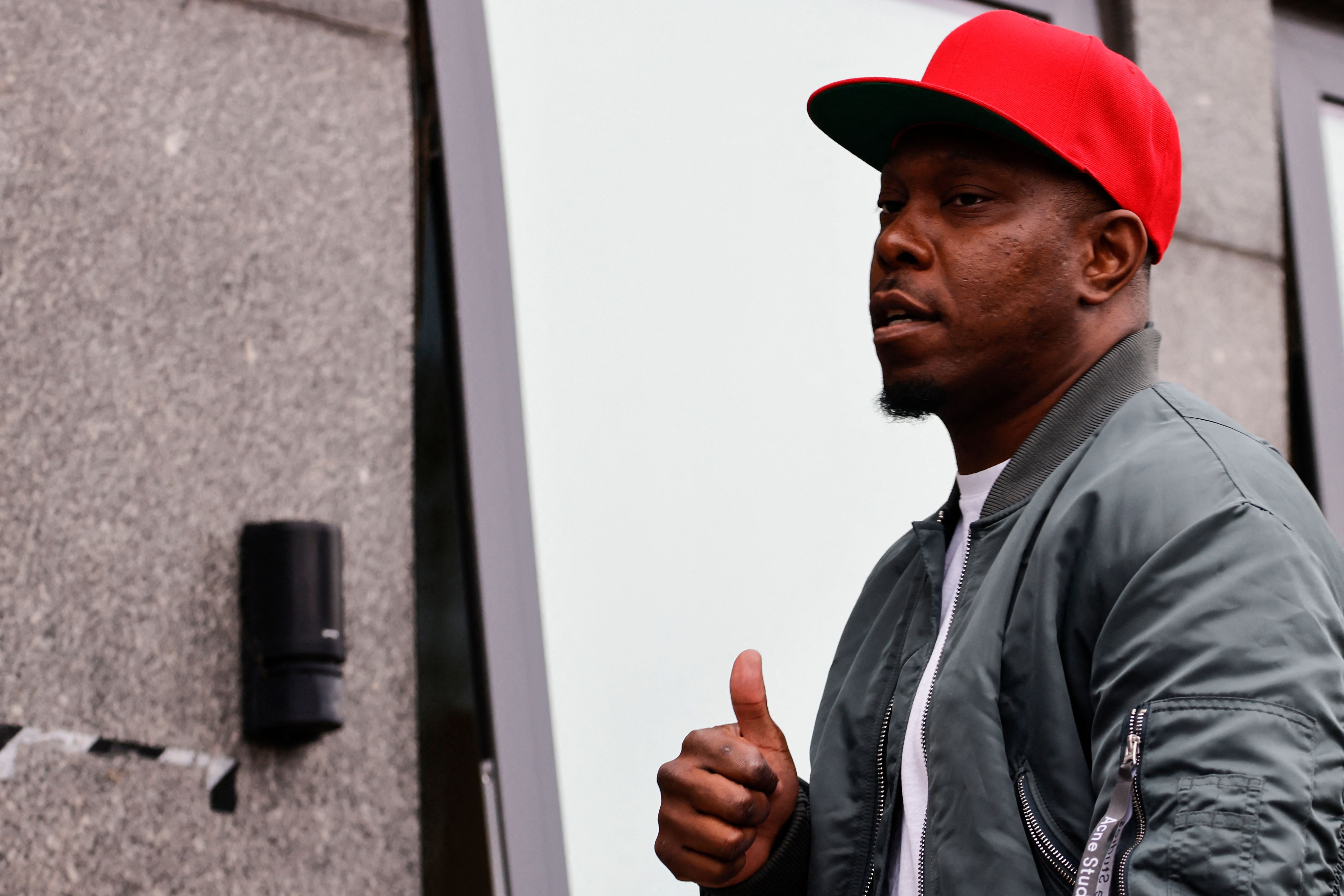 Dizzee Rascal gives photographers a thumbs up ahead of his hearing