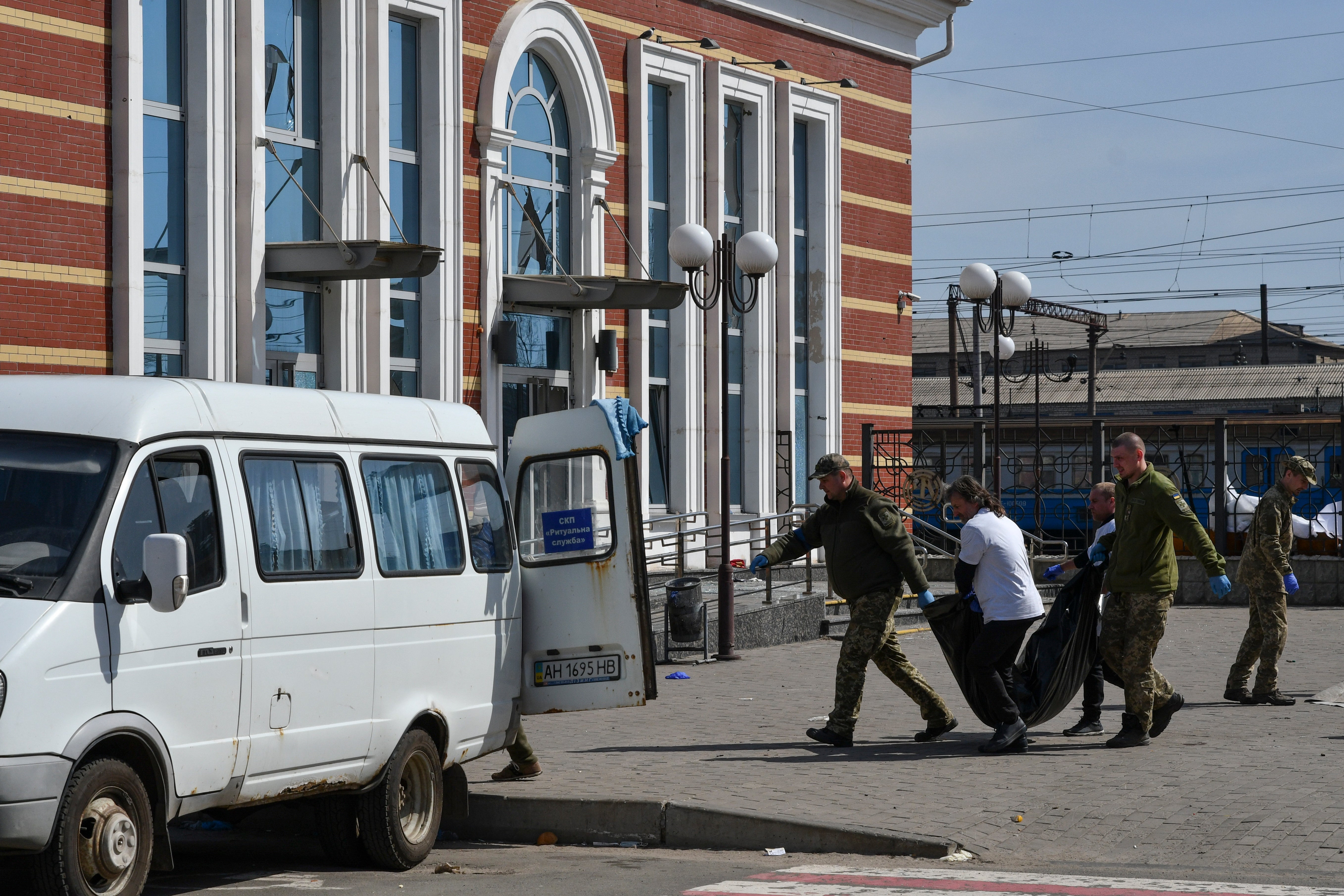 Ukrainian servicemen carry a body after Russian shelling at the railway station in Kramatorsk, Ukraine, Friday, April 8, 2022. (AP Photo/Andriy Andriyenko)