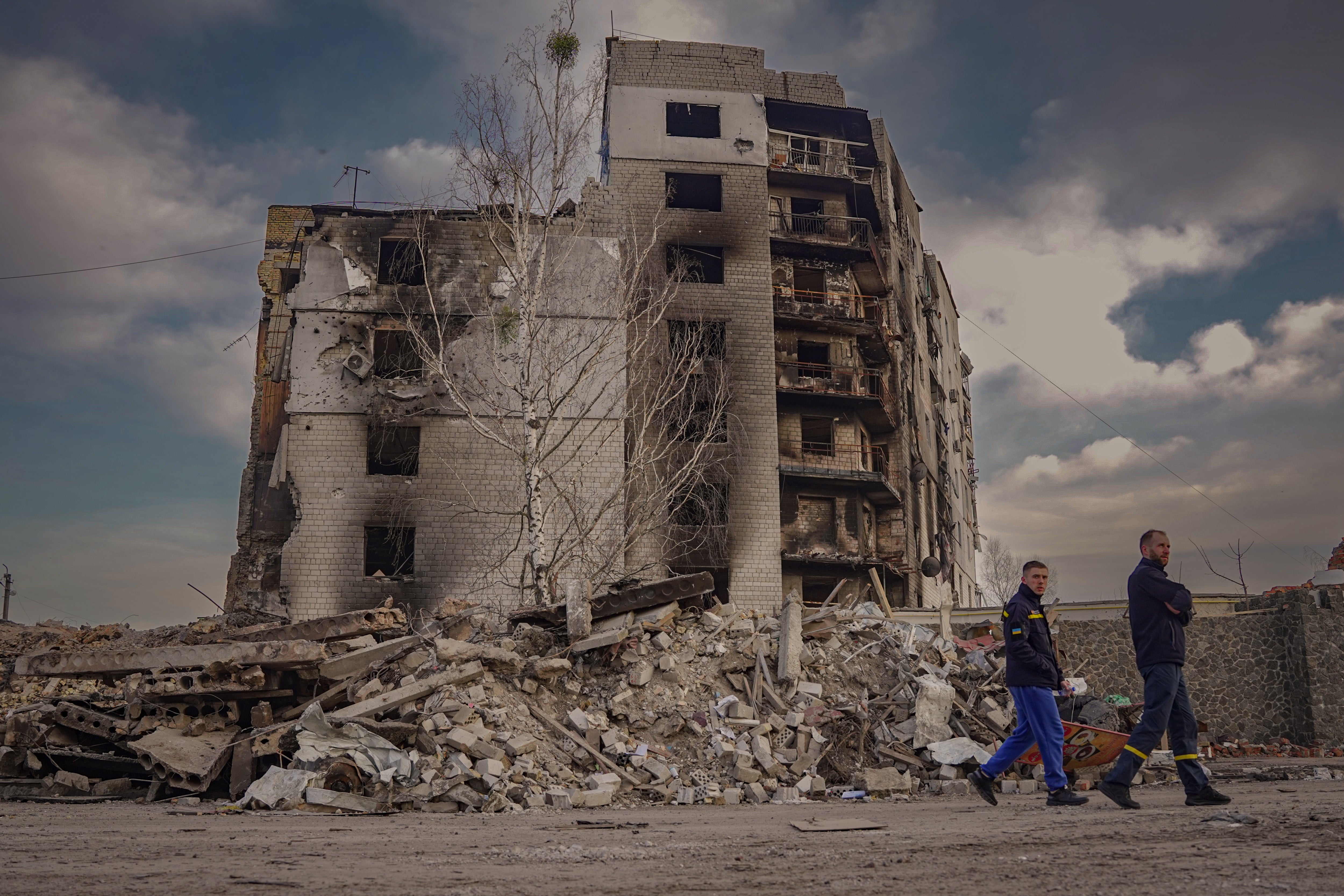 Firefighters walk by the destroyed remains of Borodyanka