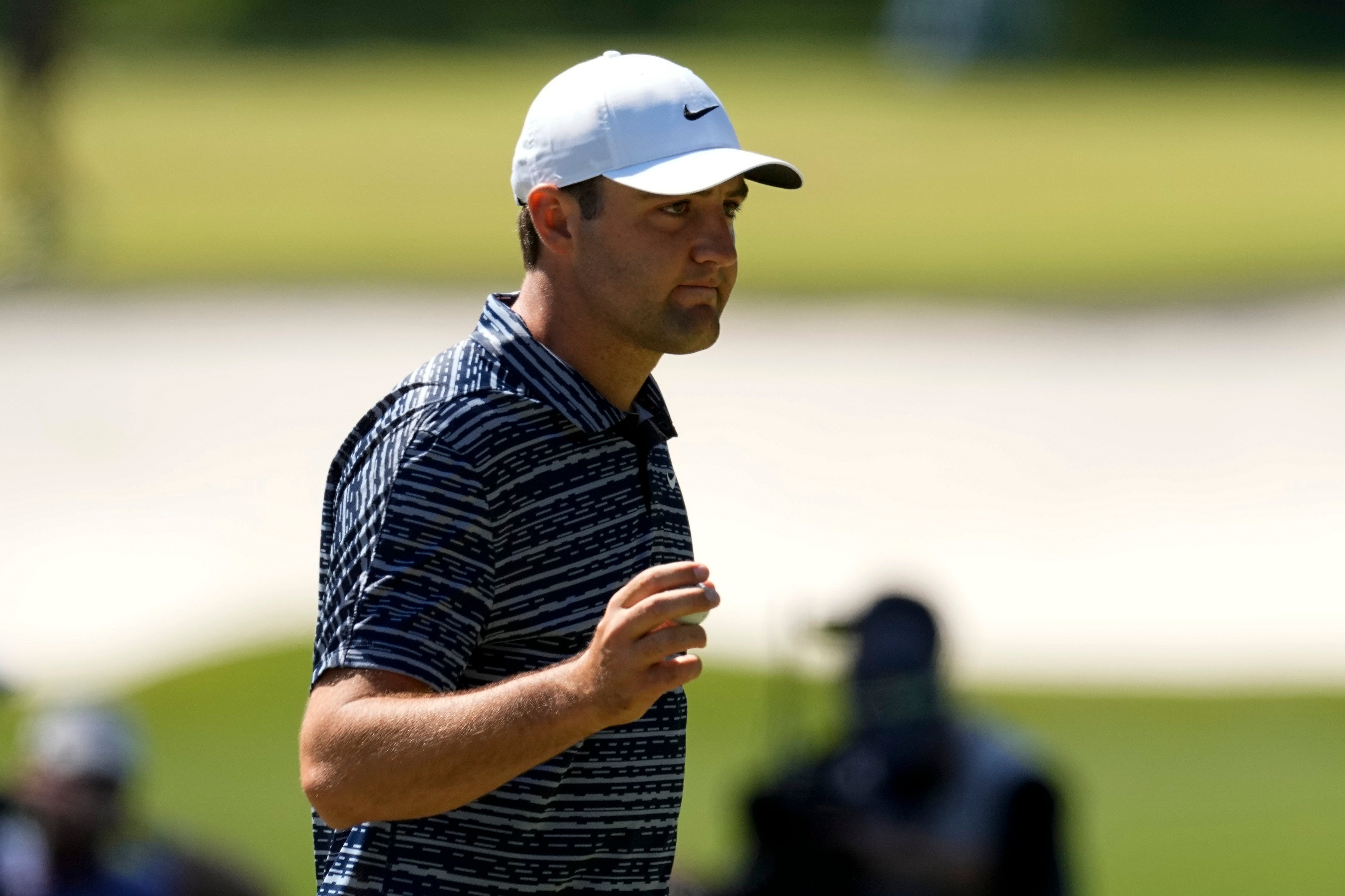 Scottie Scheffler holds up his ball after chipping in for birdie on the third hole during the final round of the Masters (Robert F. Bukaty/AP)