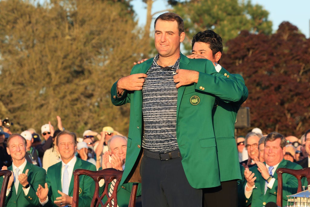 Scottie Scheffler receives the green jacket from previous champion Hideki Matsuyama