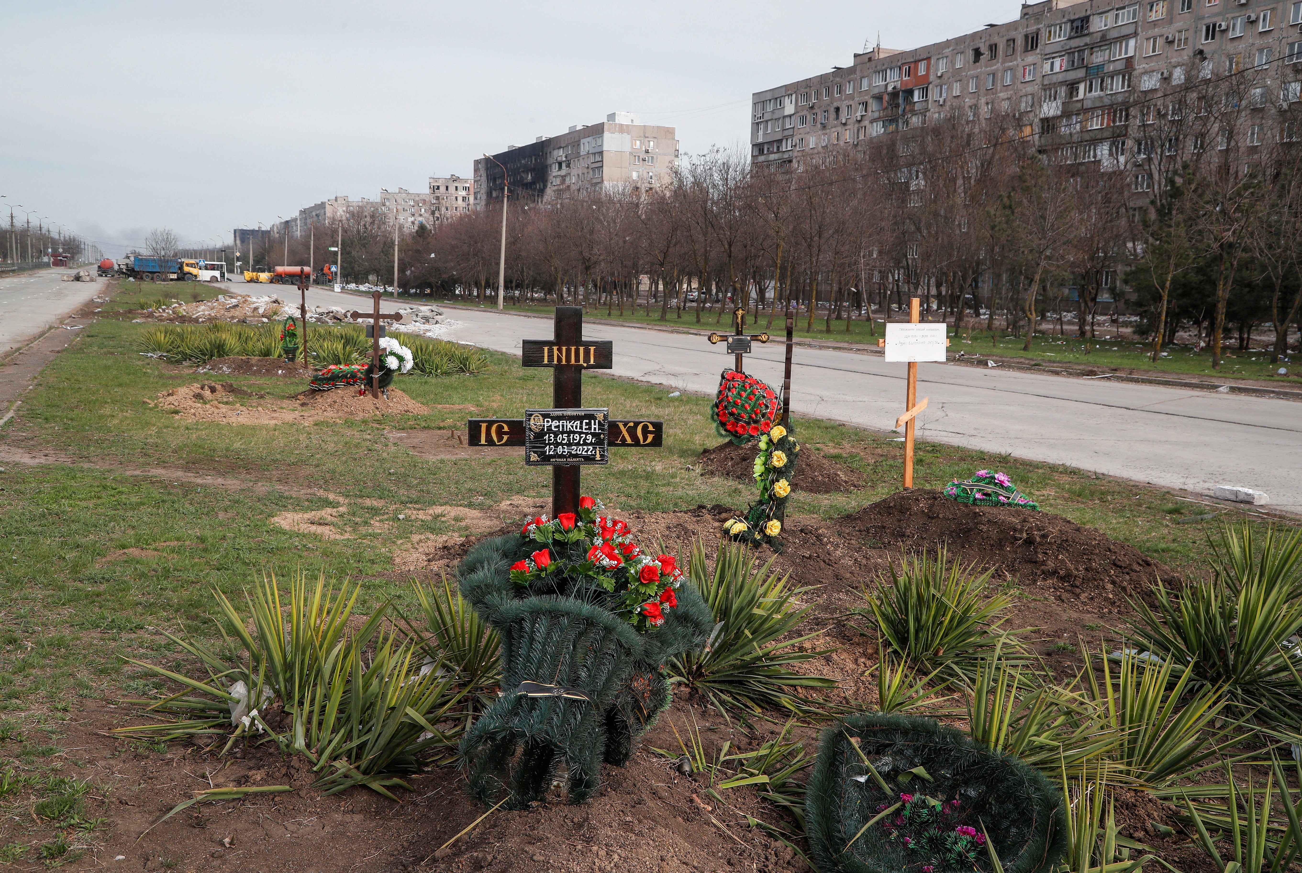 Graves of civilians killed during Ukraine-Russia conflict are seen next to apartment buildings in the southern port city of Mariupol