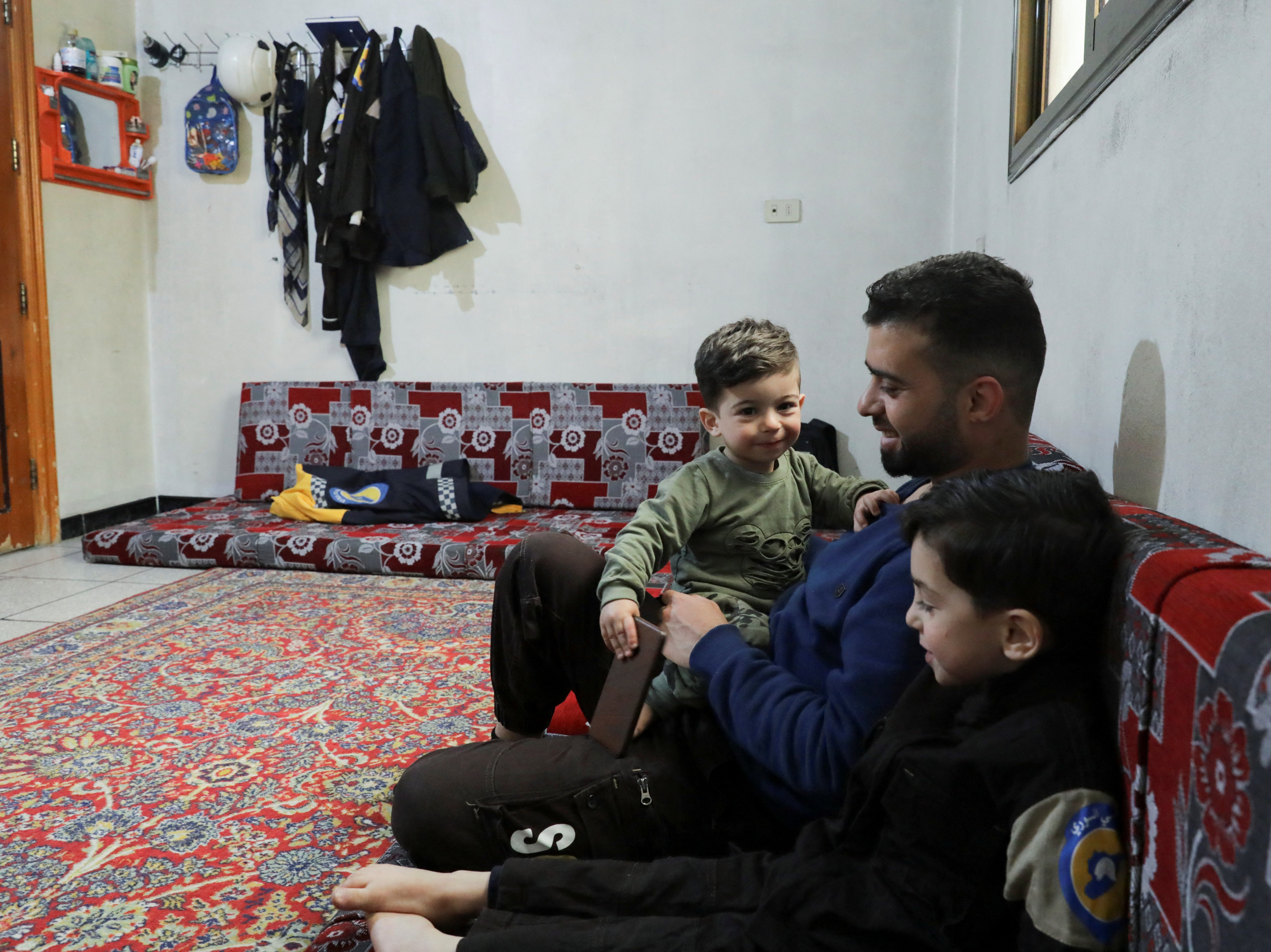 Hamid Ketteny, a civil defence rescue worker who says he carried the bodies of six children who were killed when poison gas was dropped in the town of Khan Sheikhoun in 2017, sits with his children at home in the rebel-held Idlib, Syria