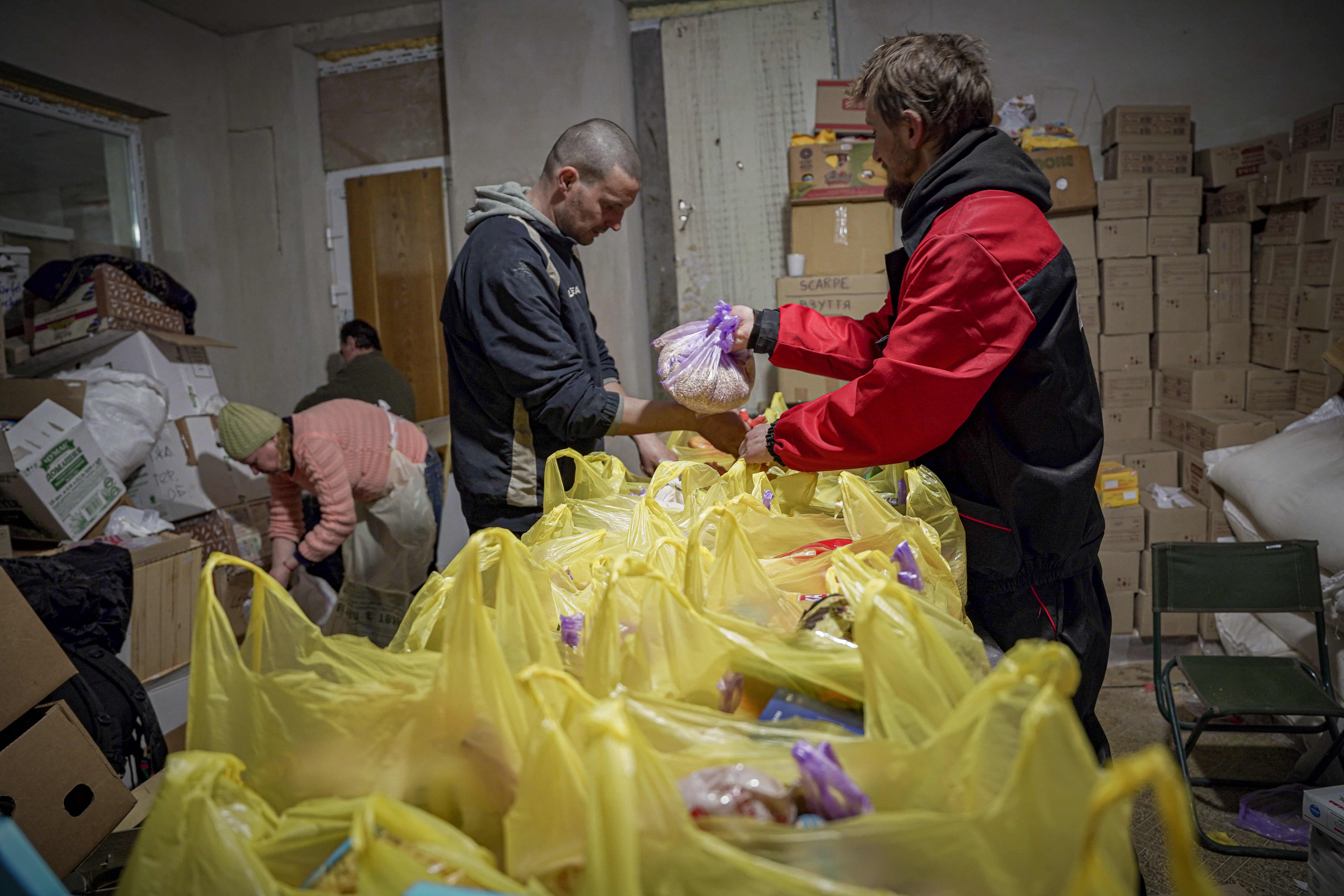 Volunteers gather food parcels together ready to villages outside of Chernihiv