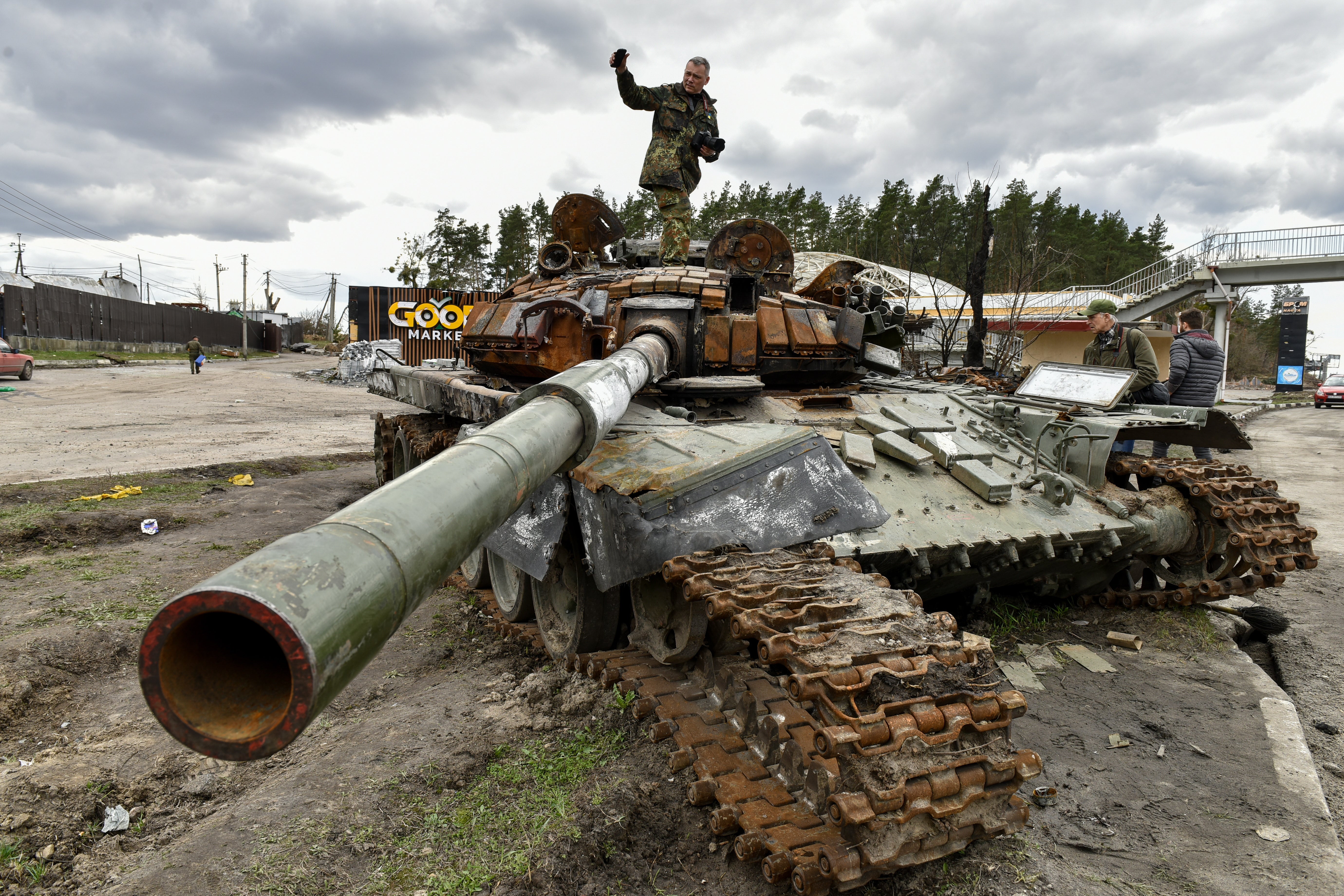 A man stands on a destroyed Russian tanks in the Buzova village of Kyiv