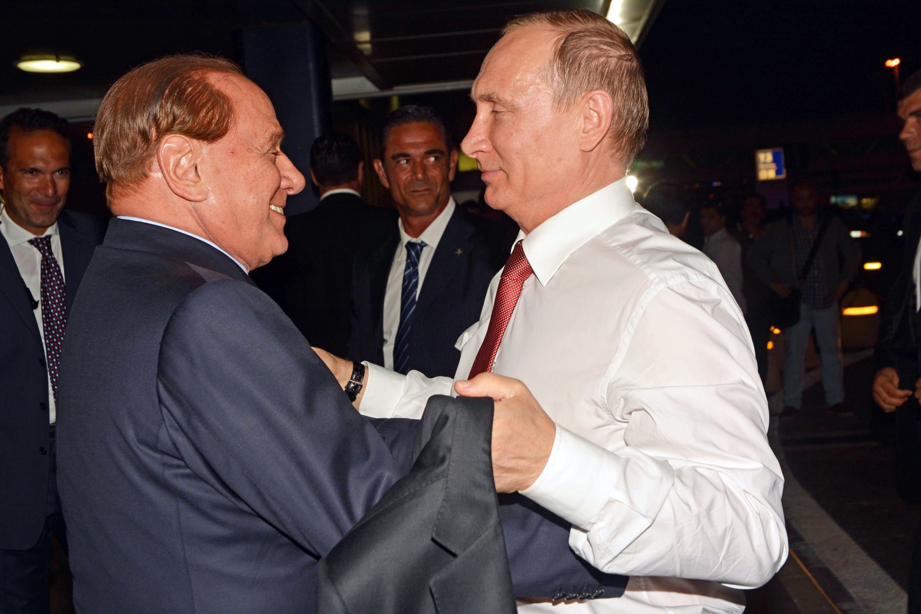 Vladimir Putin greets former Italian prime minister Silvio Berlusconi at Fiumicino Airport in Rome in 2015