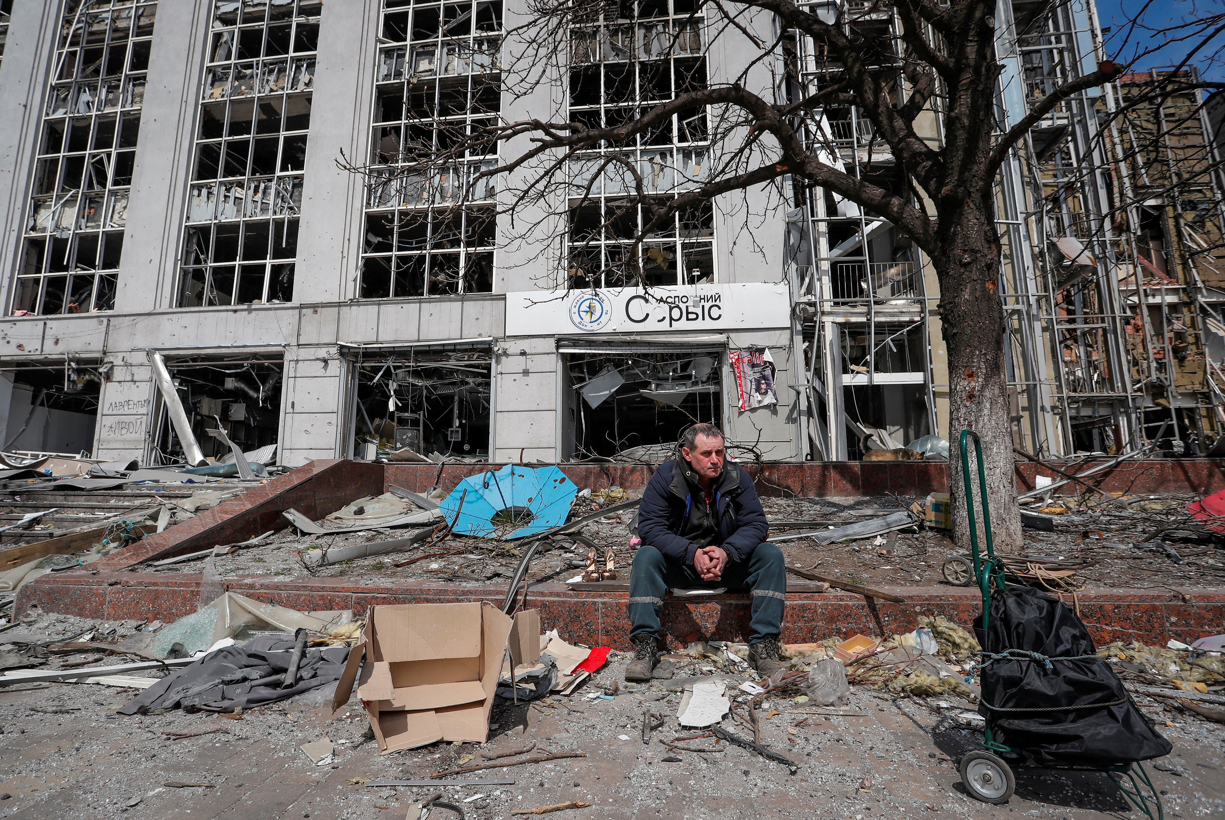 A resident looks on near a building destroyed in the course of the Ukraine-Russia conflict, in Mariupol