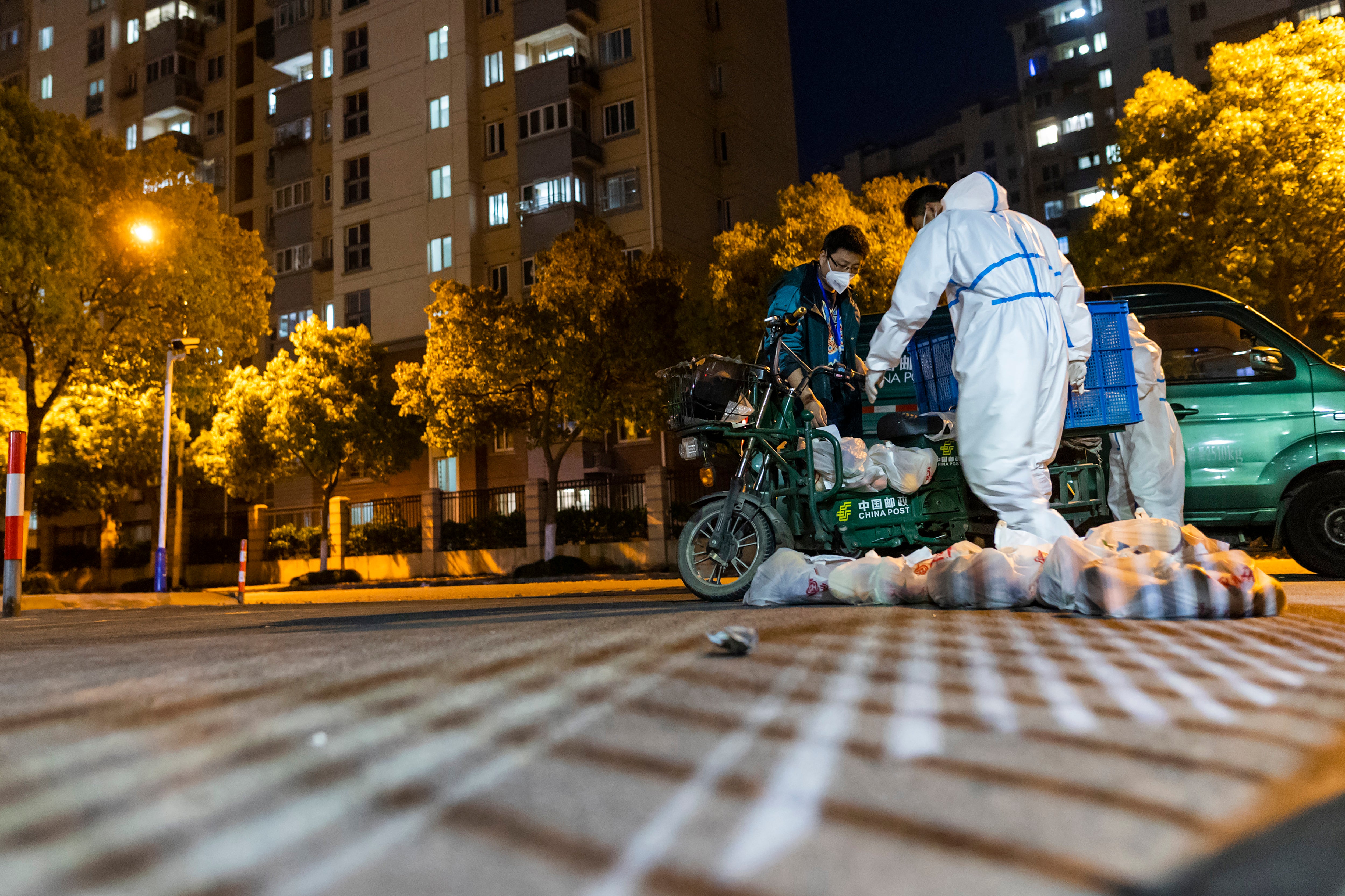 Workers bring supplies to a gate community in Shanghai