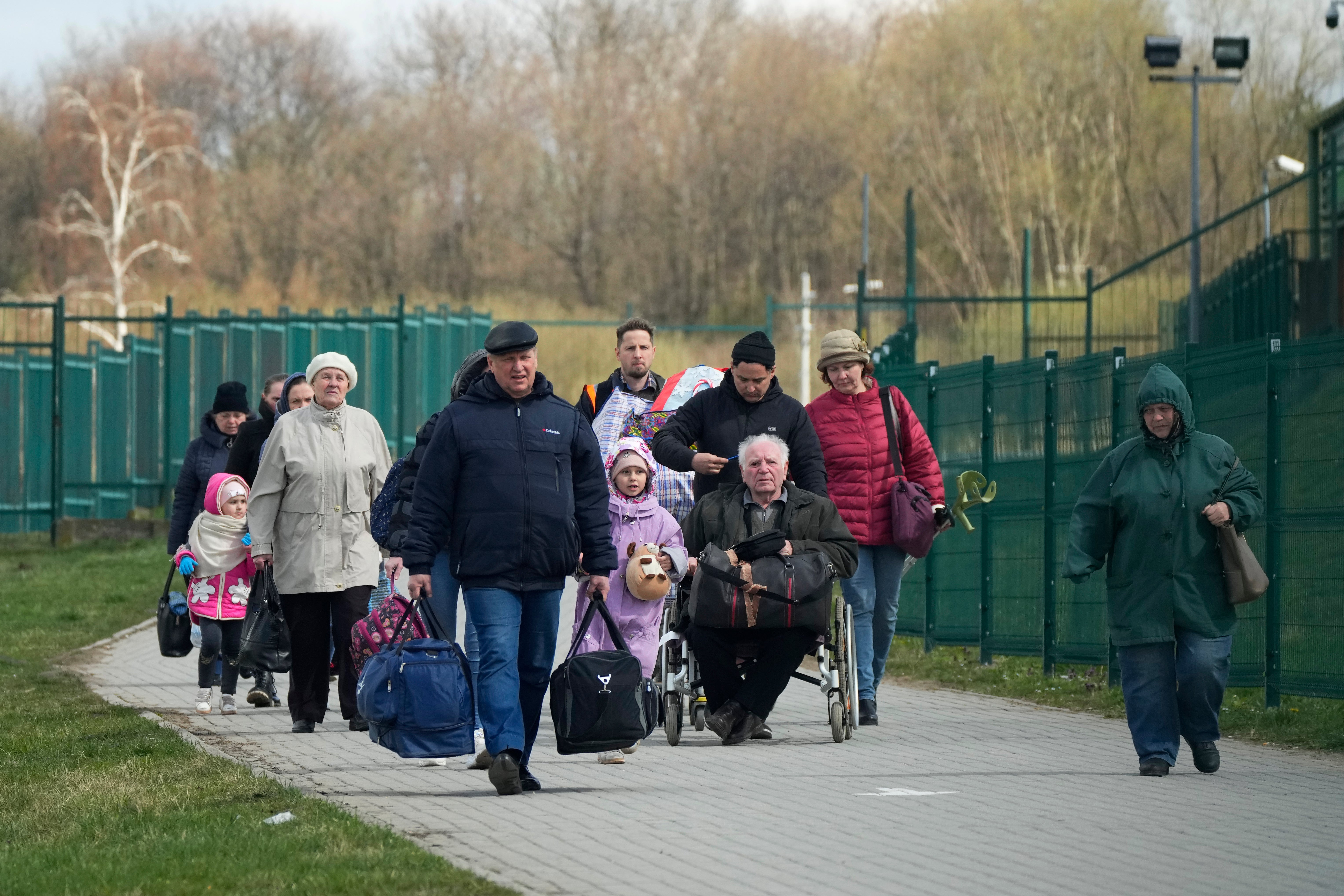 Refugees walk after fleeing the war from neighbouring Ukraine at the border crossing in Medyka, southeastern Poland