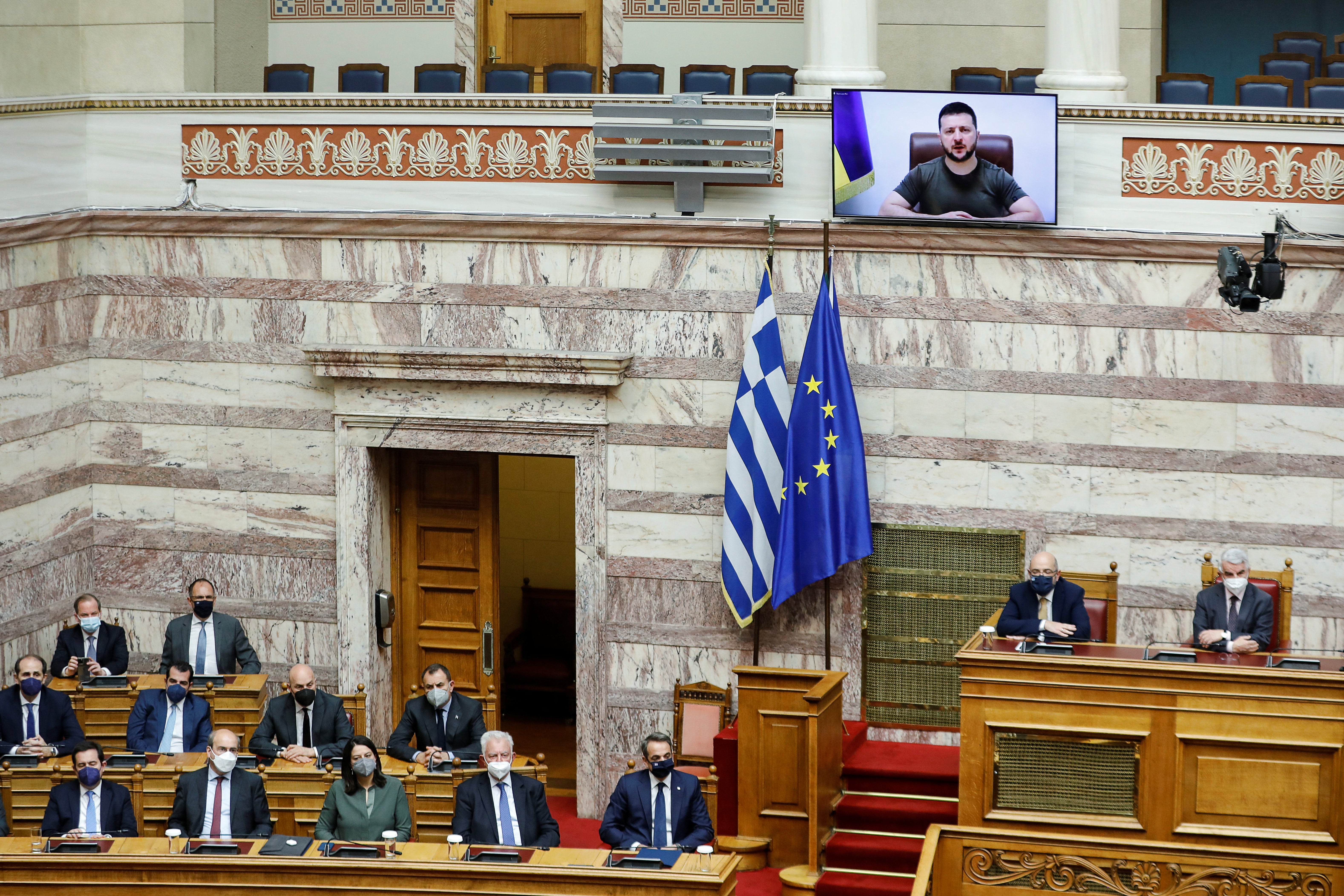 Greece’s prime minister Kyriakos Mitsotakis looks on as Ukrainian president Volodymyr Zelensky addresses the Greek parliament via teleconference in Athens