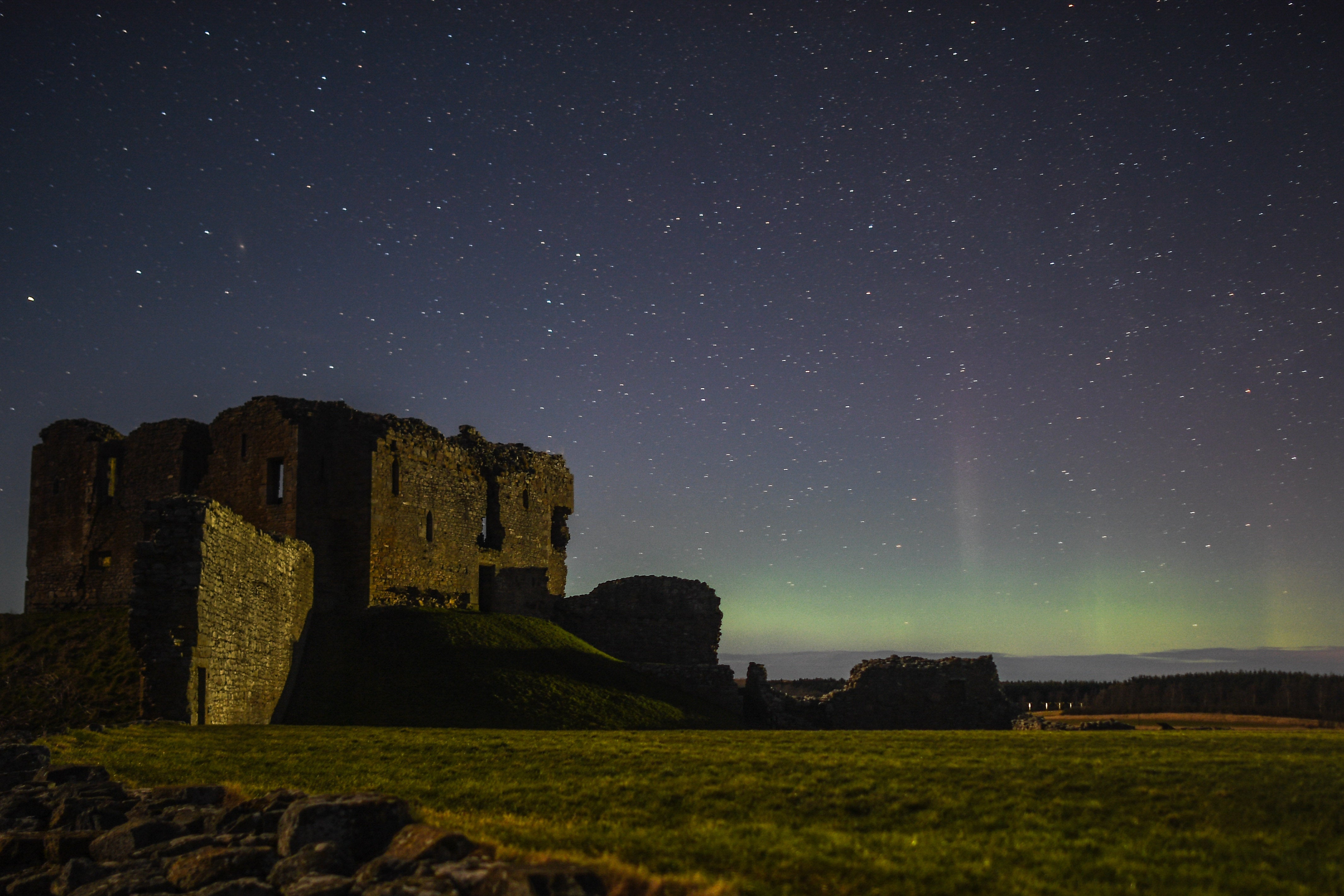 The aurora borealis is seen beyond the ruins of Duffus Castle on 20 February 2021