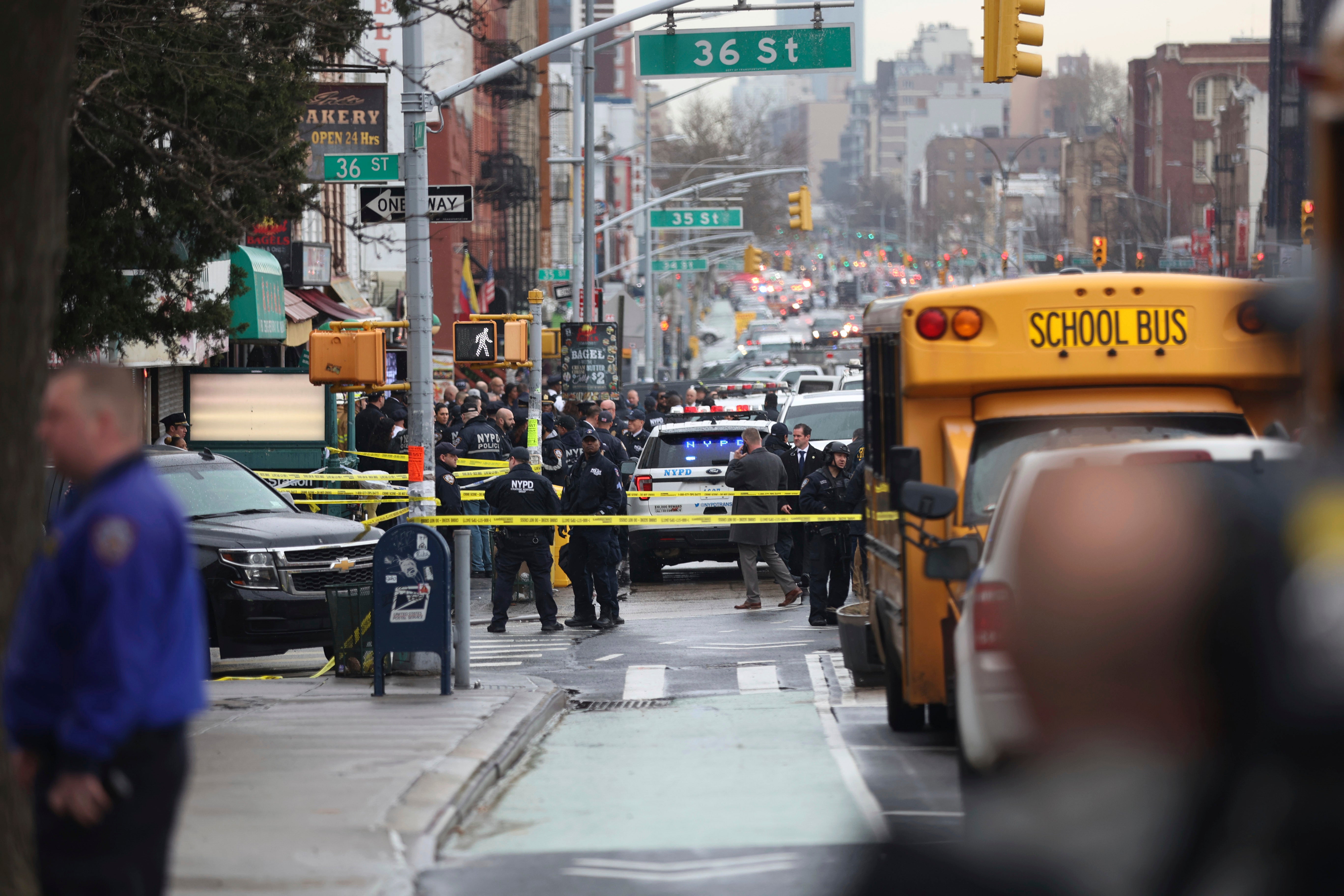 Law enforcement gather near the entrance to a subway stop in the Brooklyn borough of New York