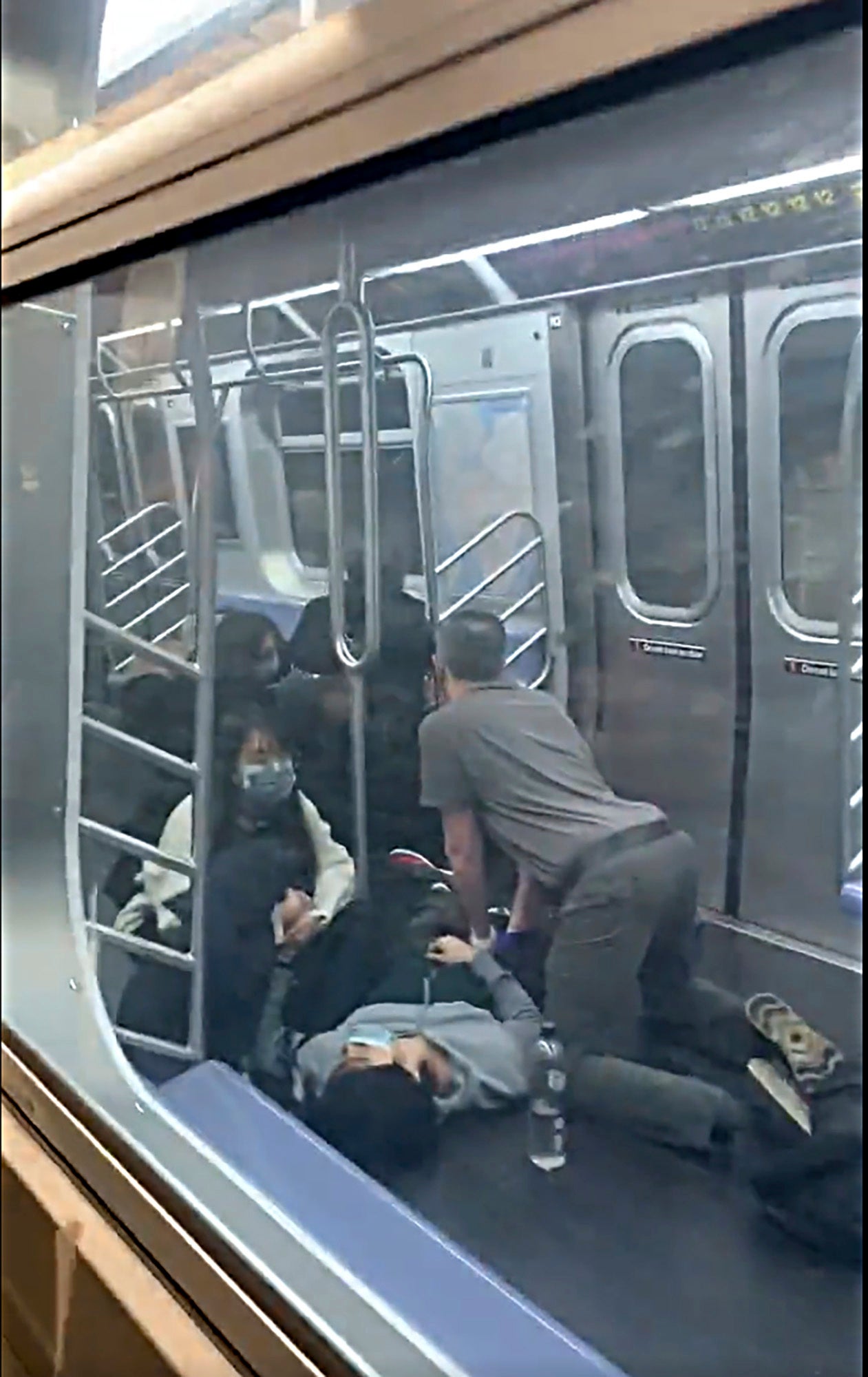 This photo provided by Will B Wylde, a person is aided in a subway car in the Brooklyn borough of New York