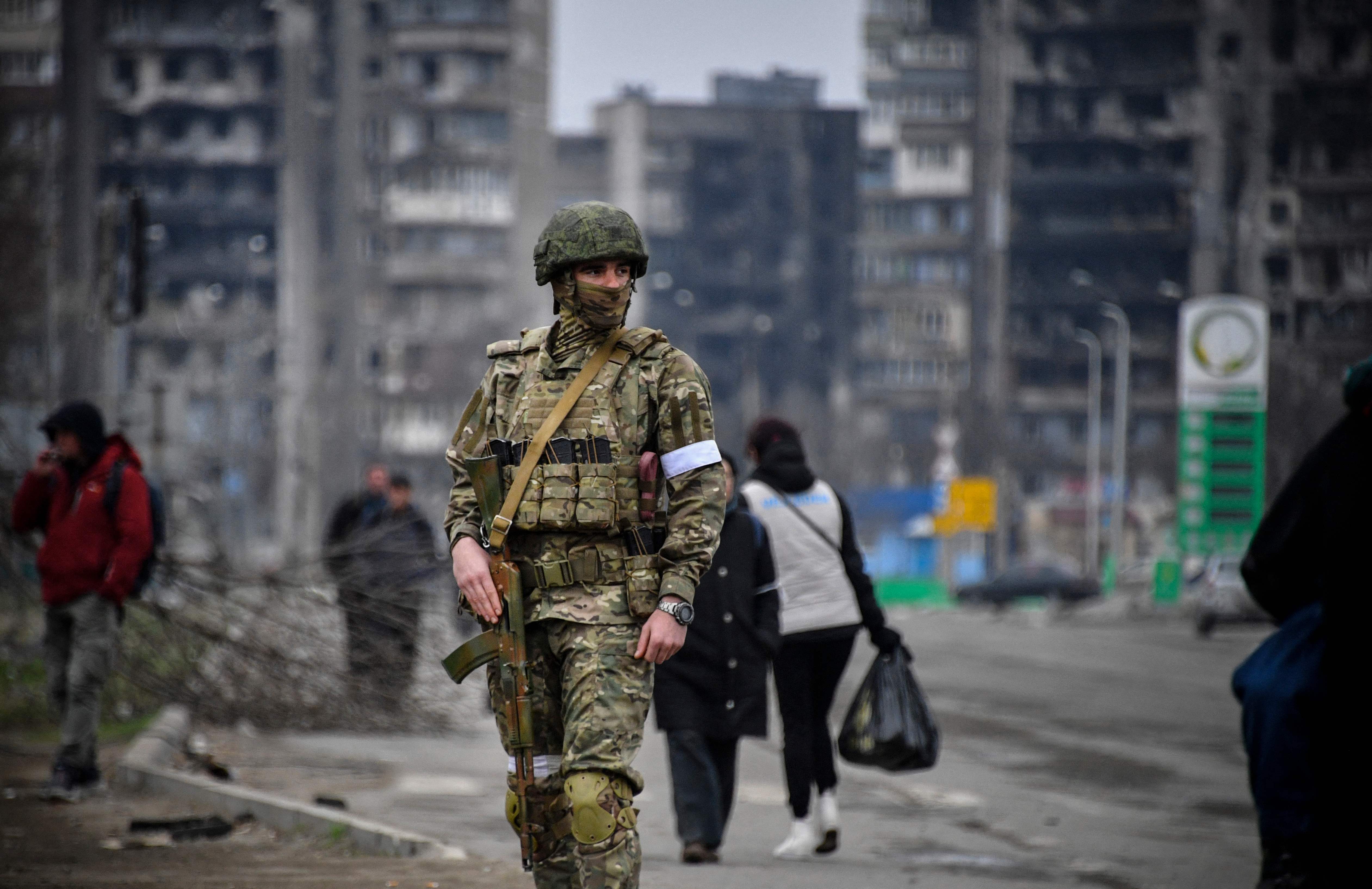 A Russian soldier patrols in a street of Mariupol on 12 April