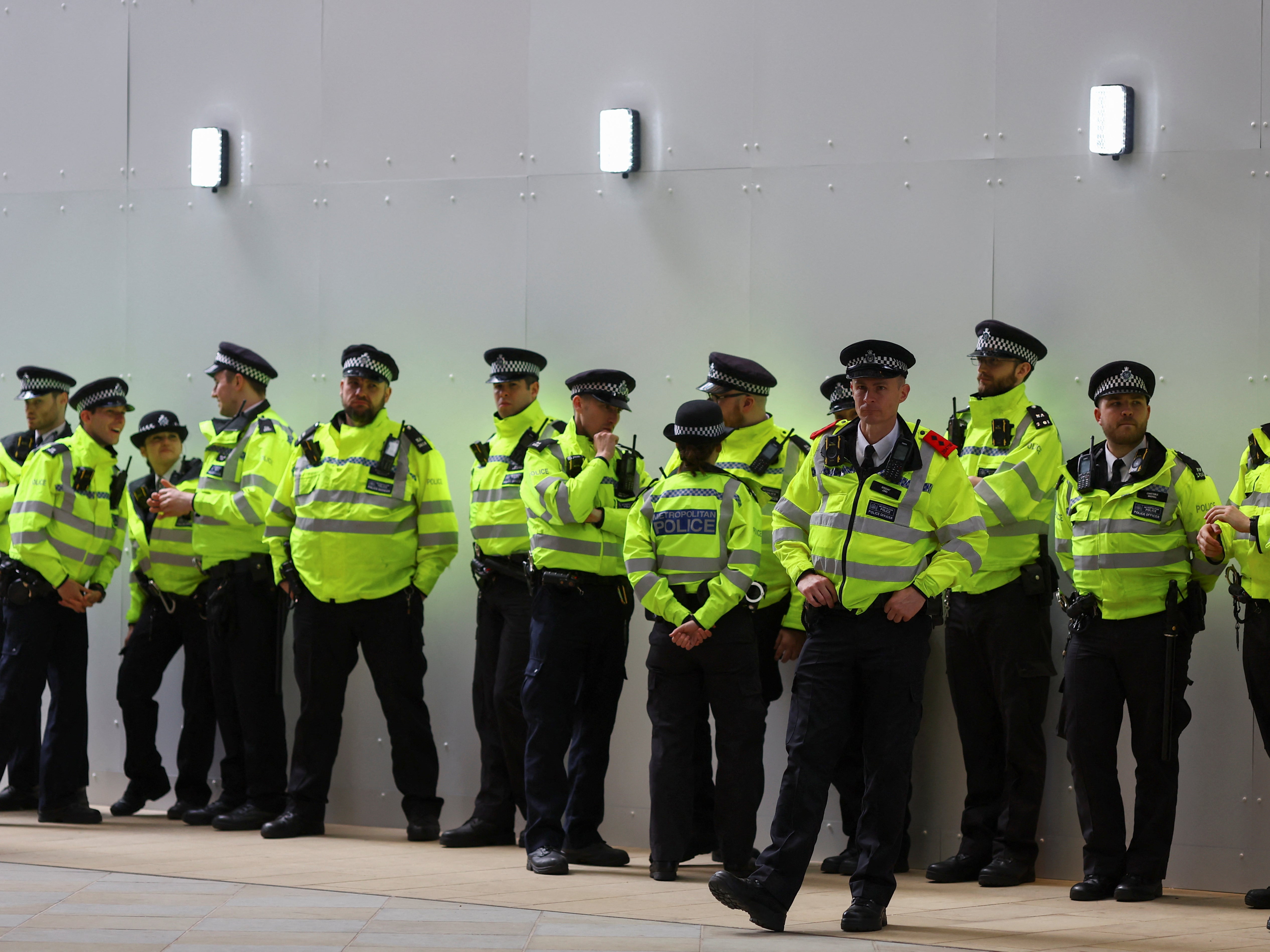 British police officers stand guard as activists from Extinction Rebellion protest at Shell's headquarters