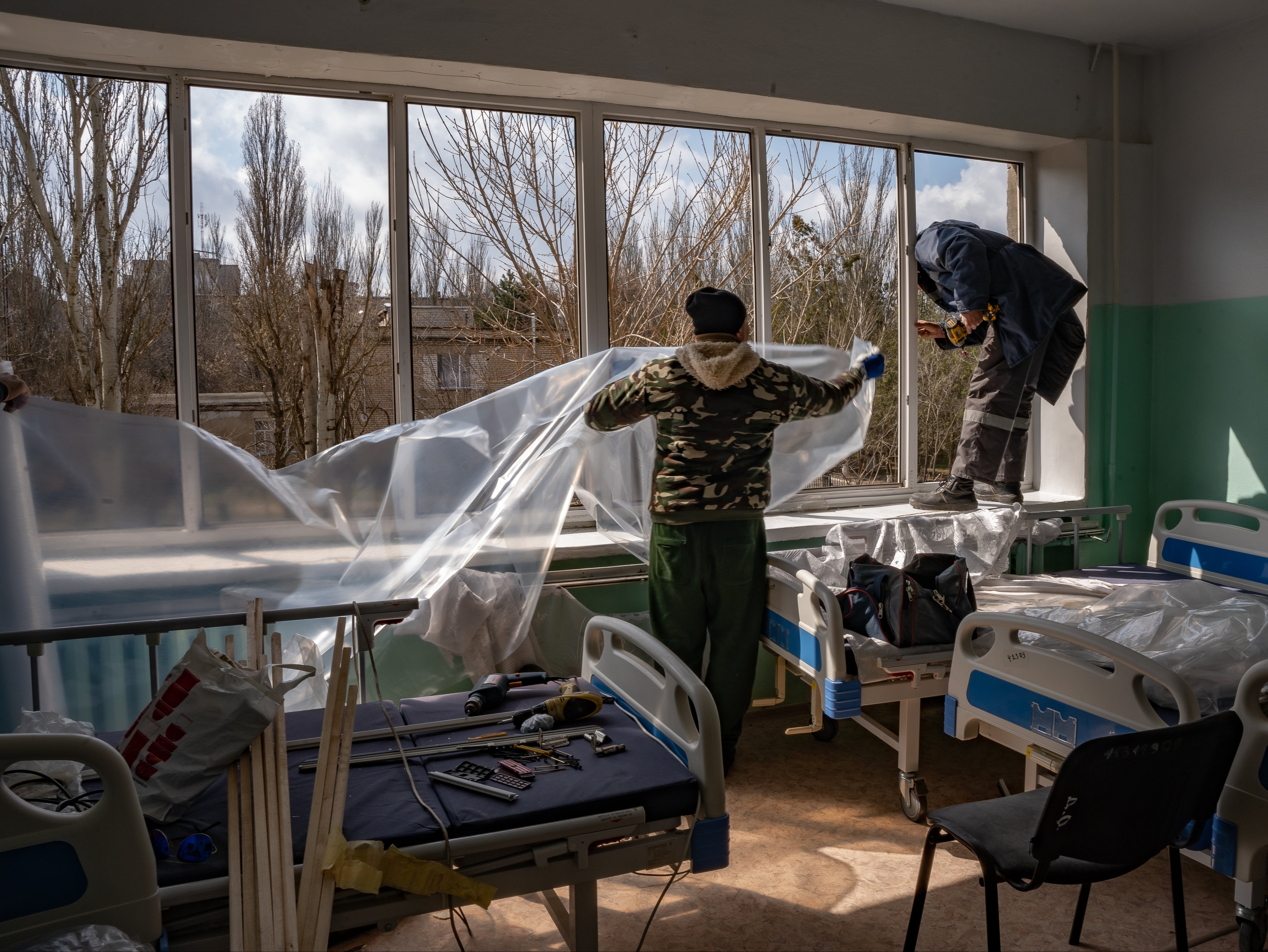 Workers repair a blown-out window of Mykolaiv’s Hospital No 5, which was hit by a missile earlier this month