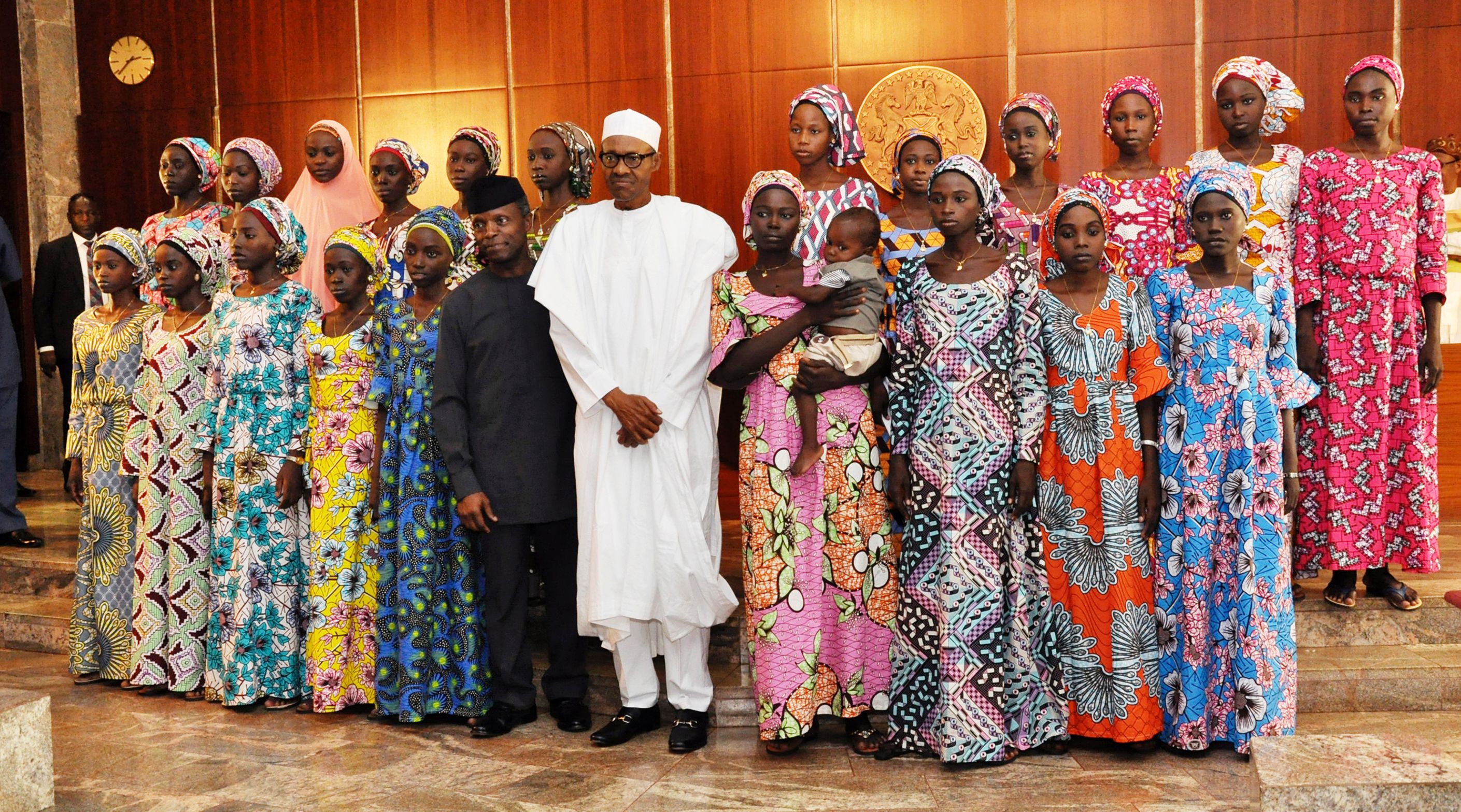 File photo: Nigerian President Muhammadu Buhari (C) poses with 21 Chibok girls who were released by Boko Haram in October 2016