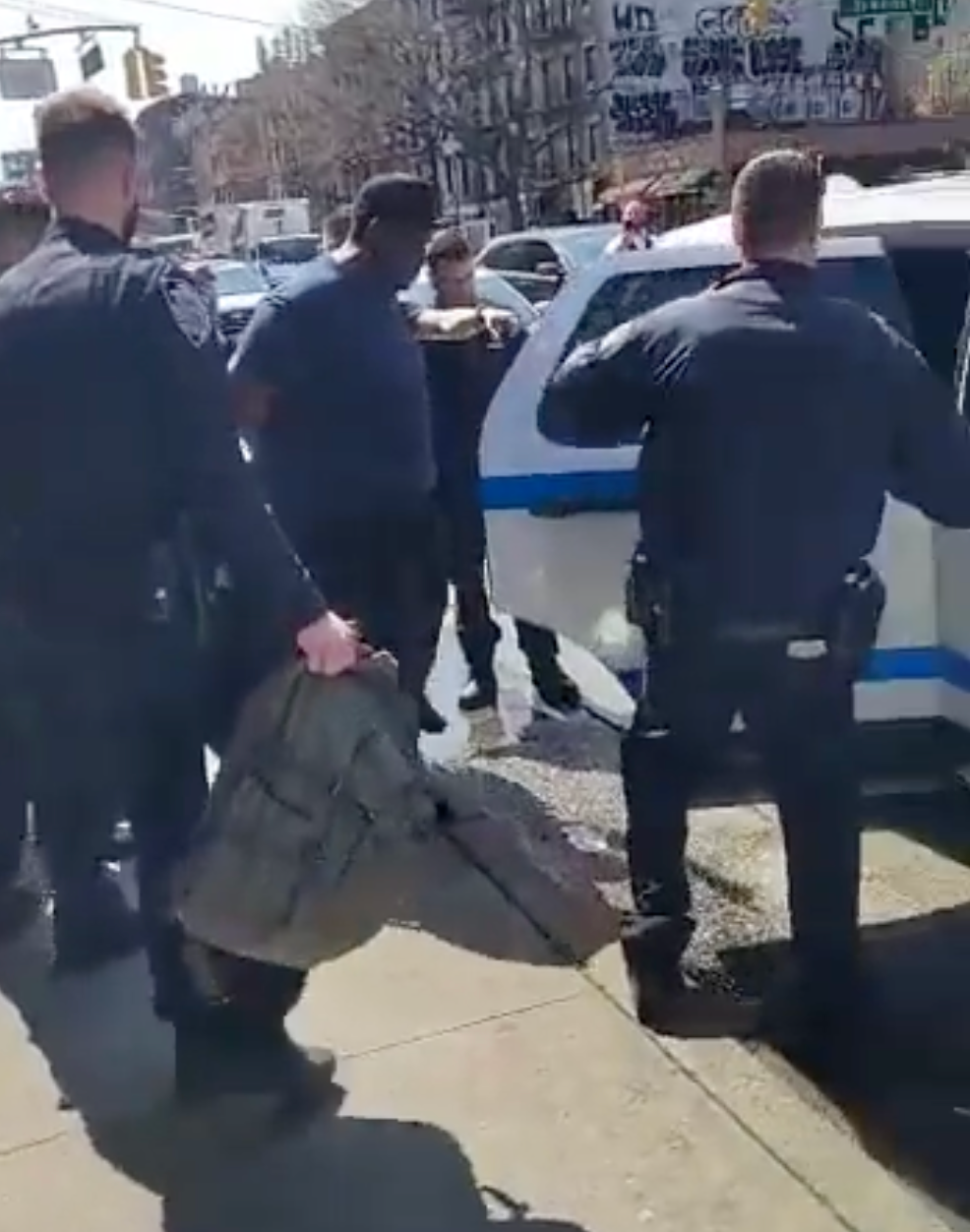 Frank James being placed into the back of a police cruise in the East Village on Wednesday