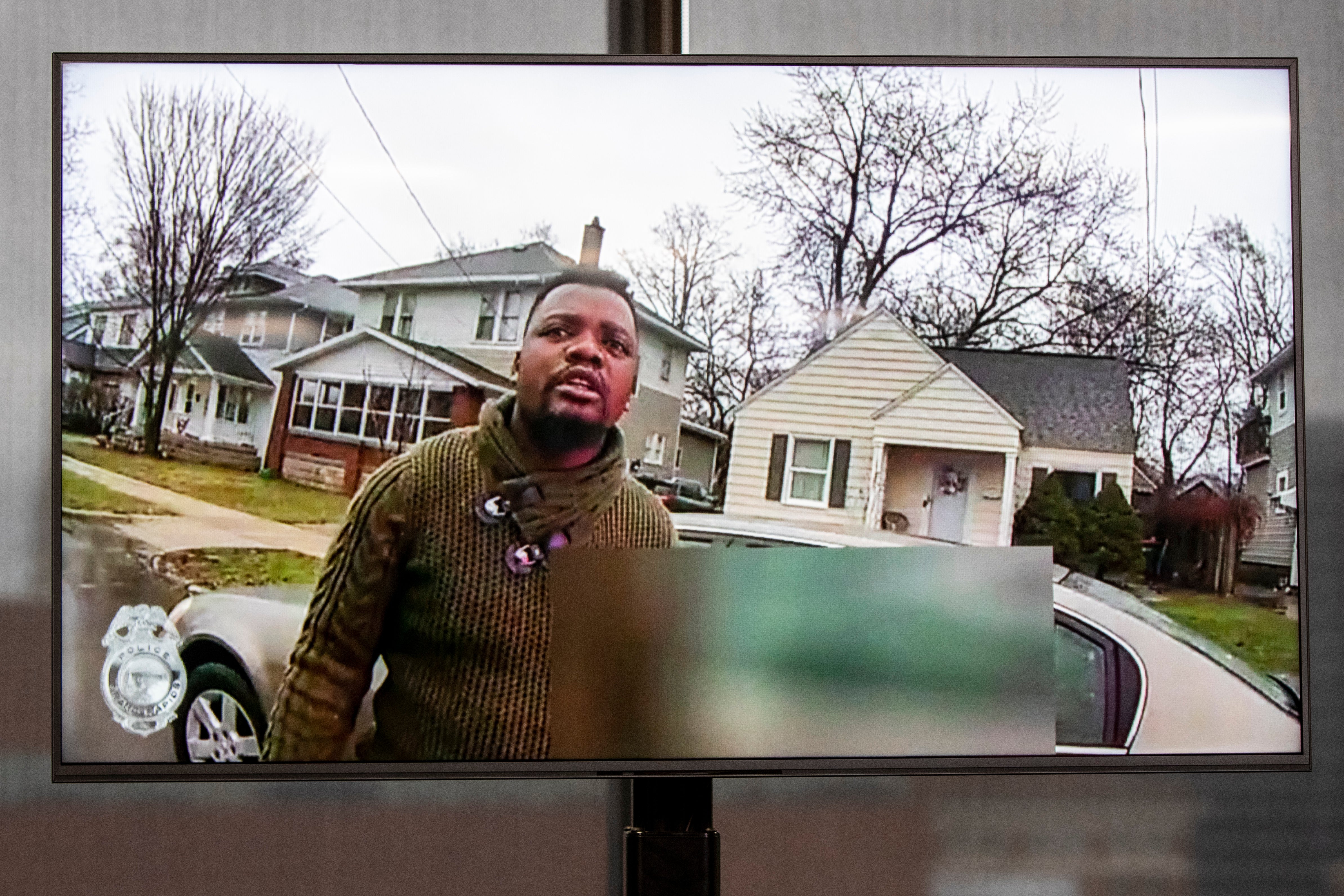 A TV display shows video evidence of a Grand Rapids police officer struggling with and shooting Patrick Lyoya