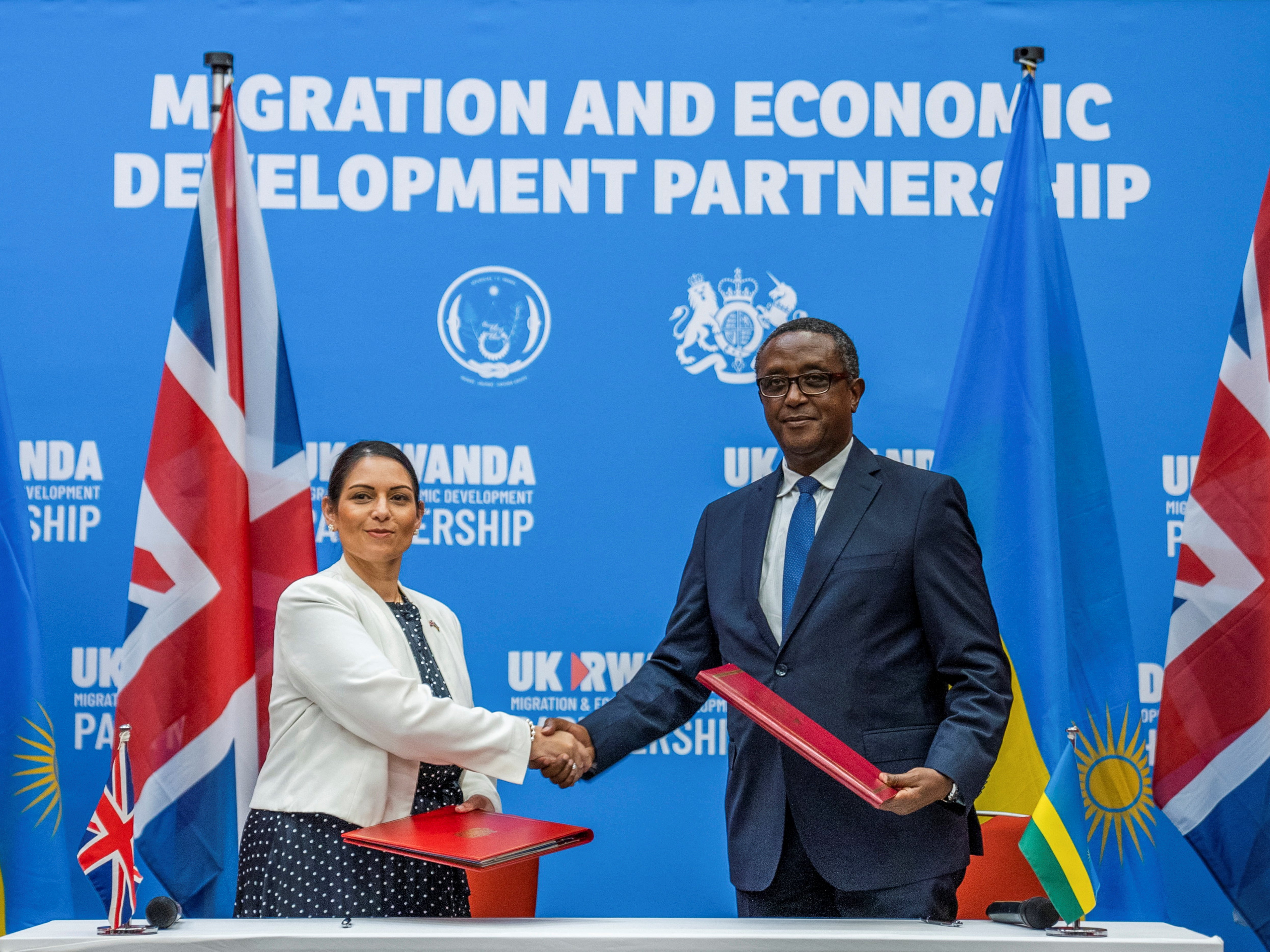 Home secretary Priti Patel shakes hands with Rwandan foreign minister Vincent Birutaare after signing the partnership agreement at a joint news conference in Kigali, Rwanda