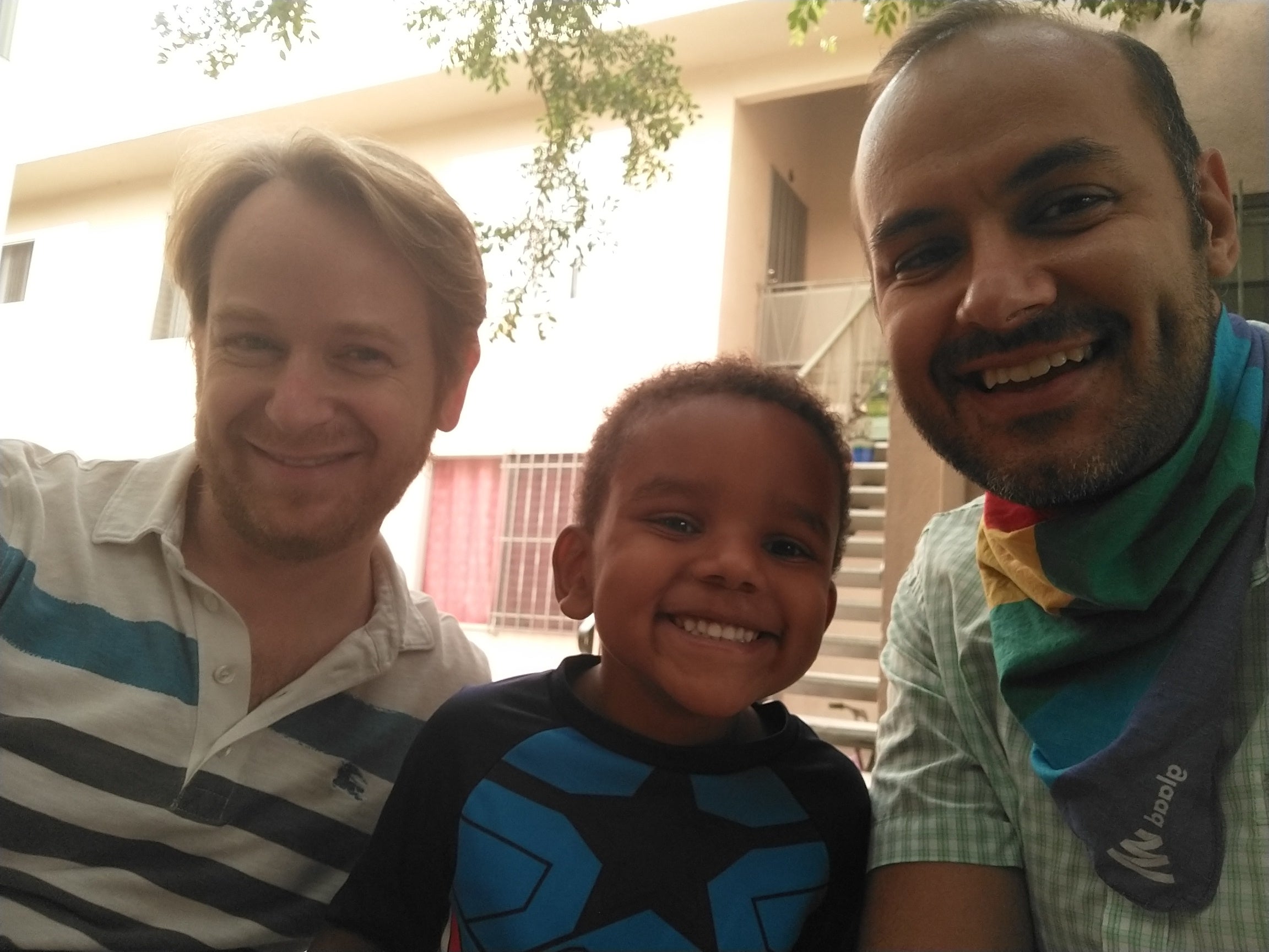 Robbie Pierce, right, with his husband Neal Broverman and their son