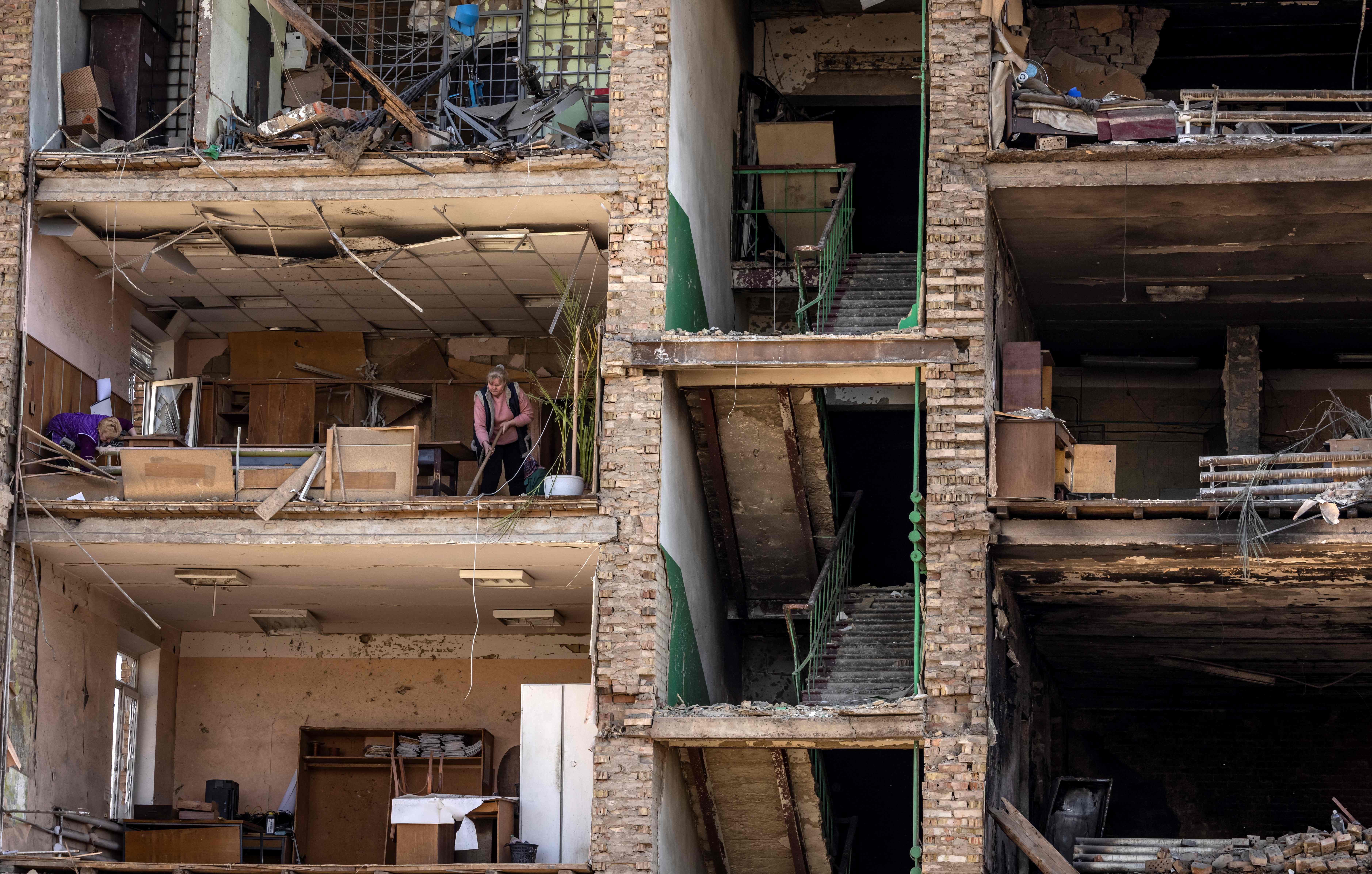 Women clean in a building with a collapsed facade at the Vizar company military-industrial complex, after the site was hit by overnight Russian strikes, in the town of Vyshneve, southwestern suburbs of Kyiv