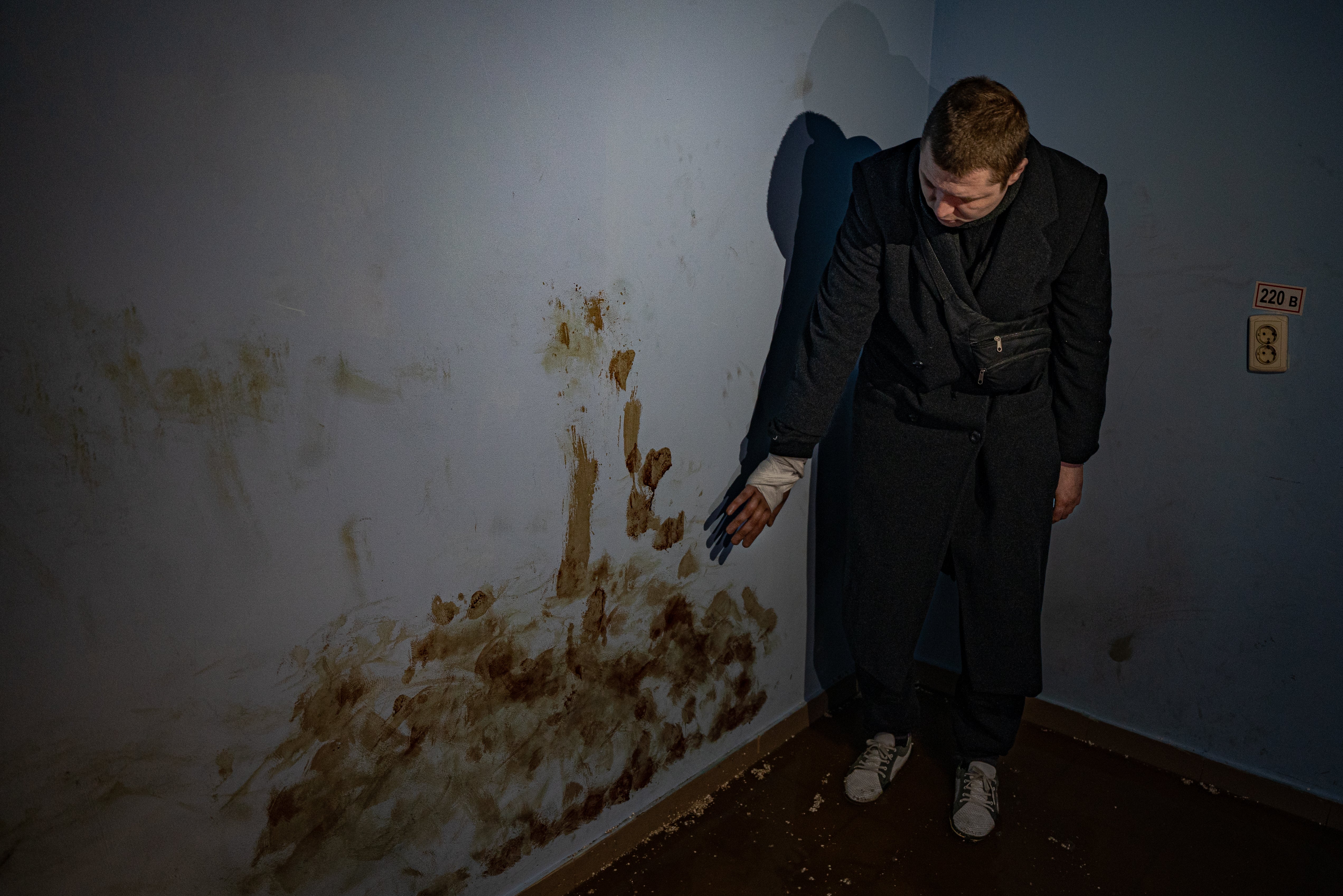 Andrei one of eight civilians held in an underground torture chamber in Trostyanets shows his blood on the wall of the cell