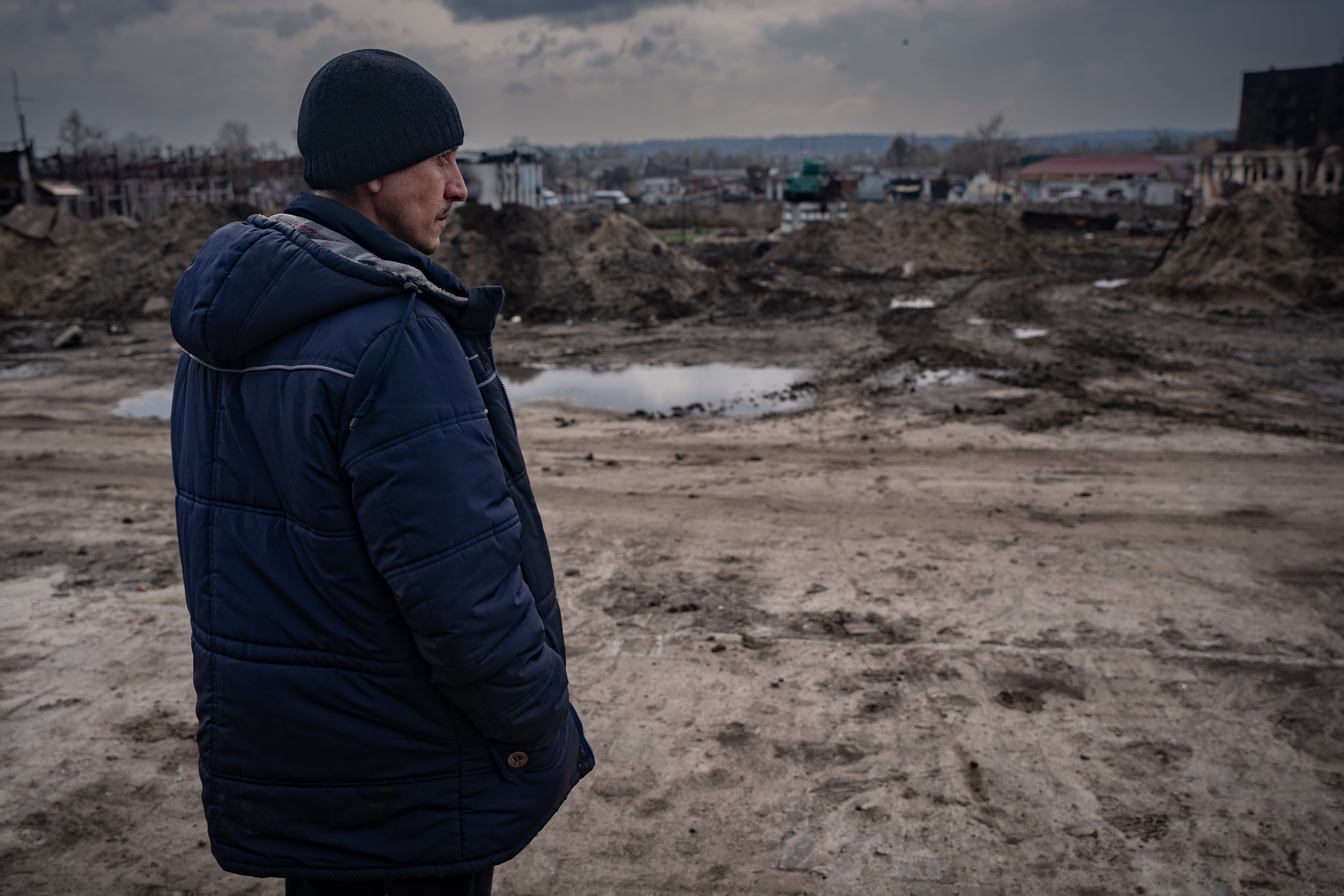 Dima stands outside the train station where he was held and tortured, which is now a blasted battlescape