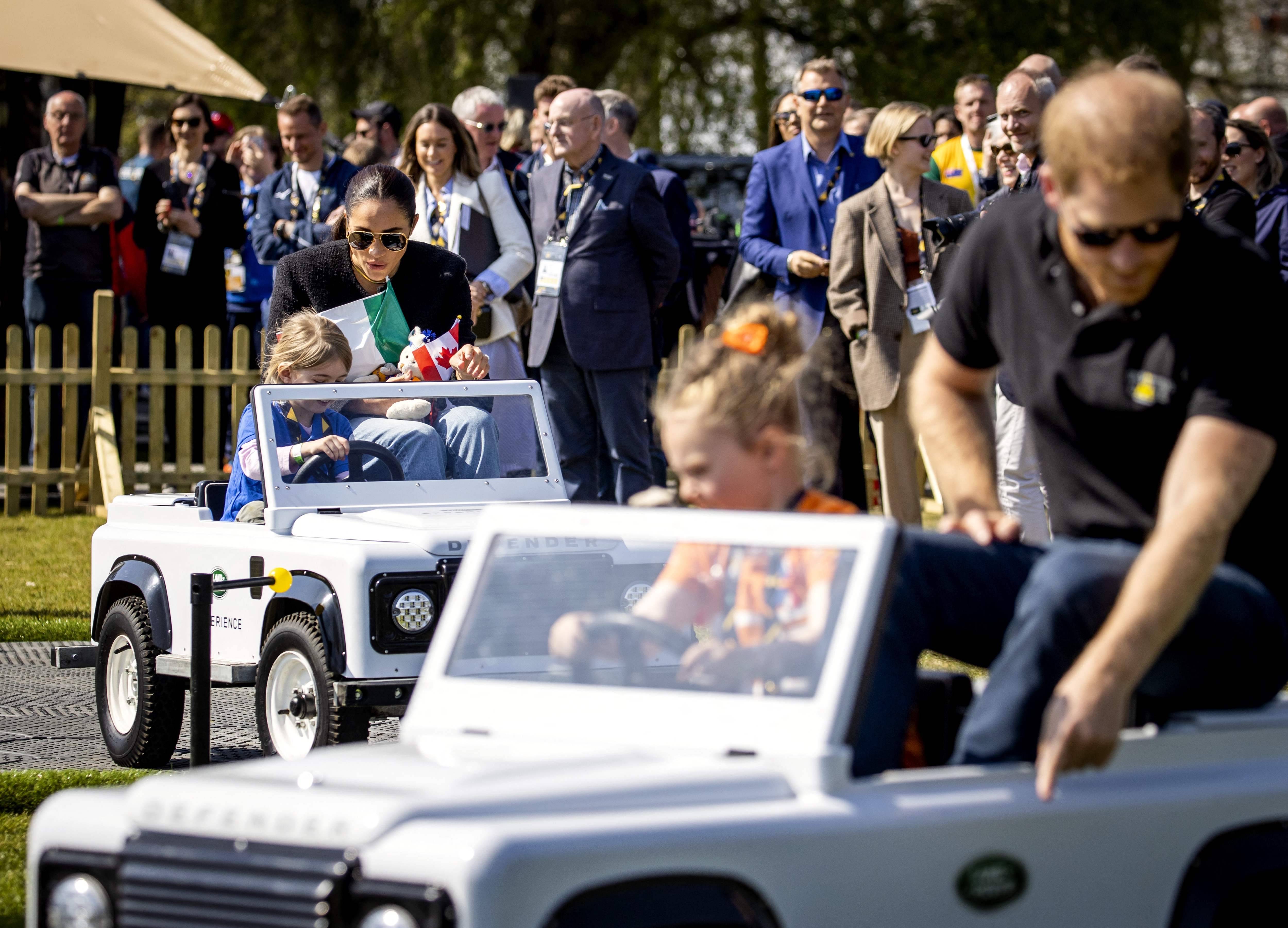 The royal couple look on children ride in toy cars at the Invictus Games