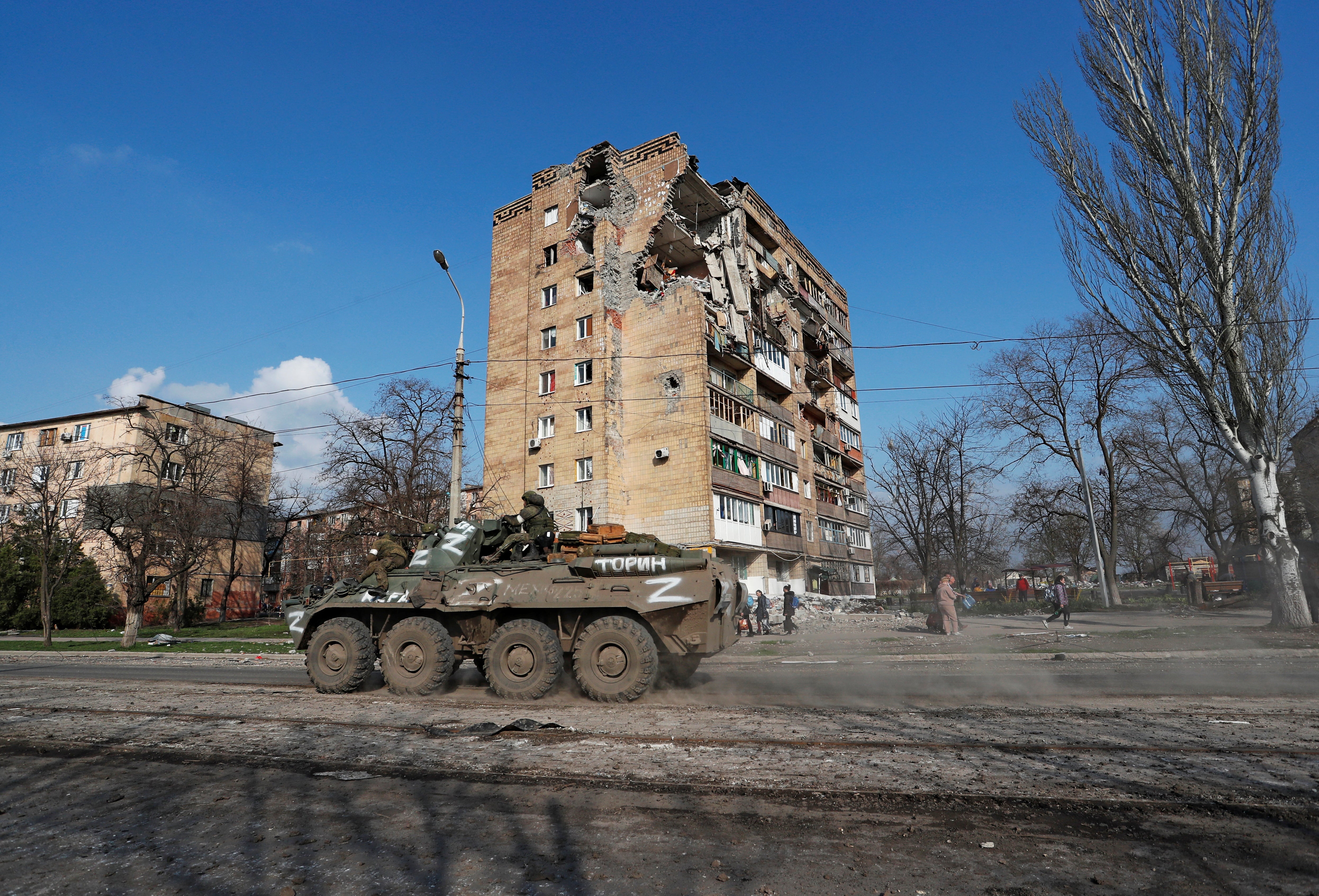 Service members of pro-Russian troops ride an armoured personnel carrier during Ukraine-Russia conflict in the southern port city of Mariupol