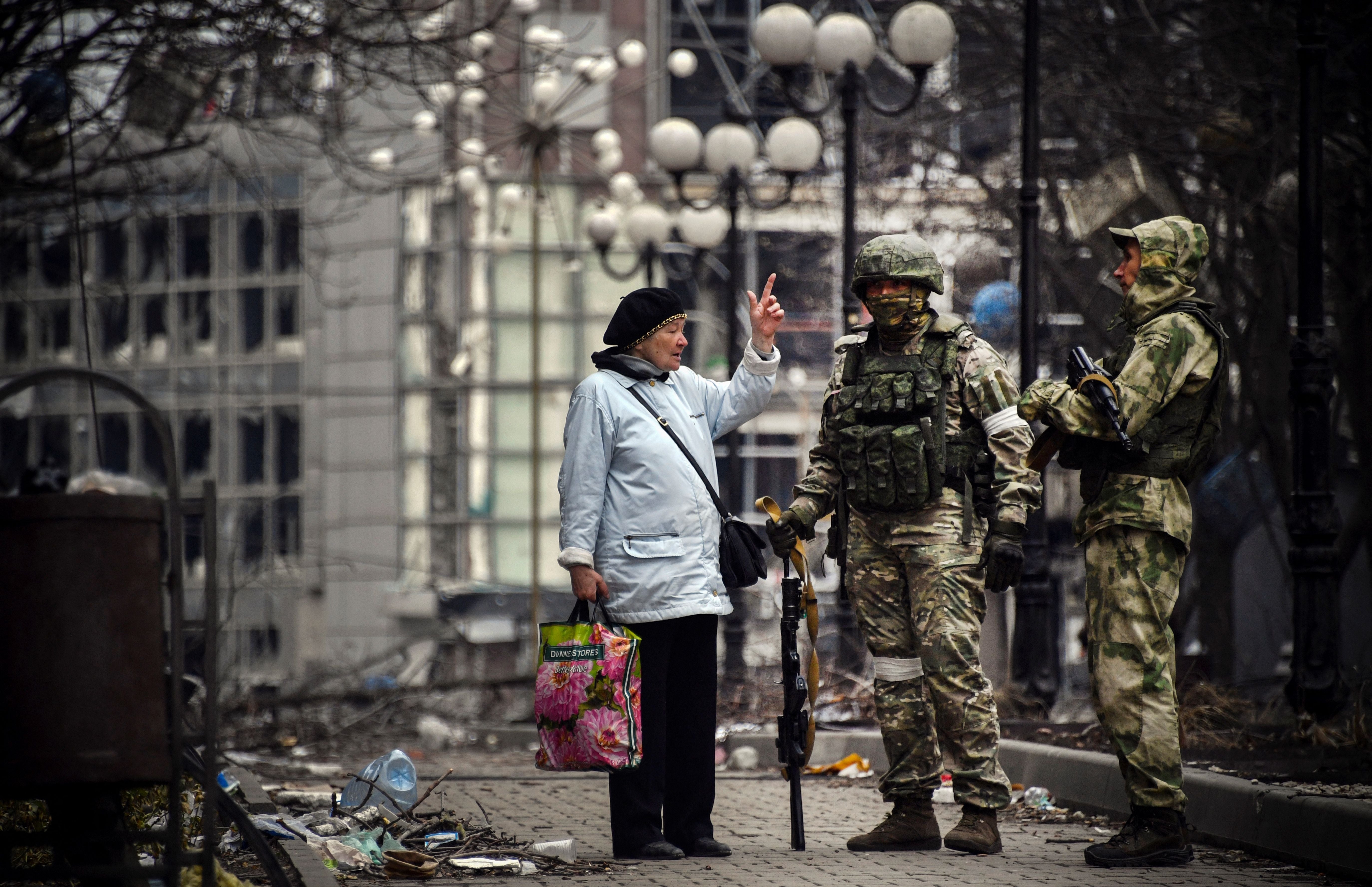 A woman remonstrates with Russian soldiers in Mariupol on April 12