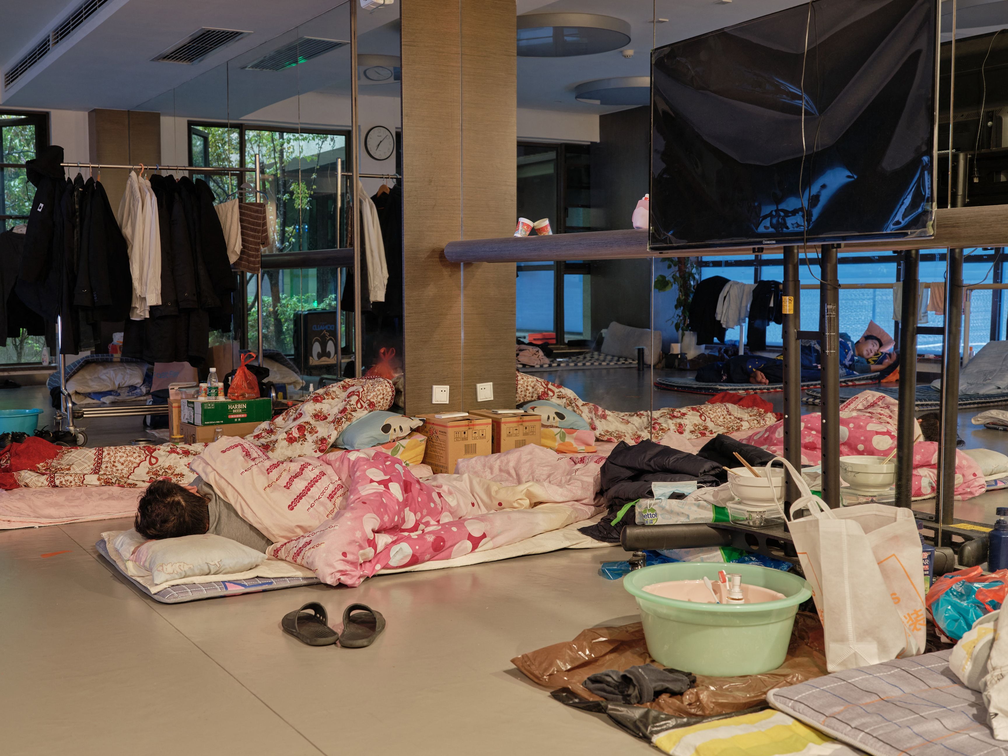 A community worker takes a nap at a temporary bed at a gym in a compound during a Covid-19 lockdown in Pudong district in Shanghai