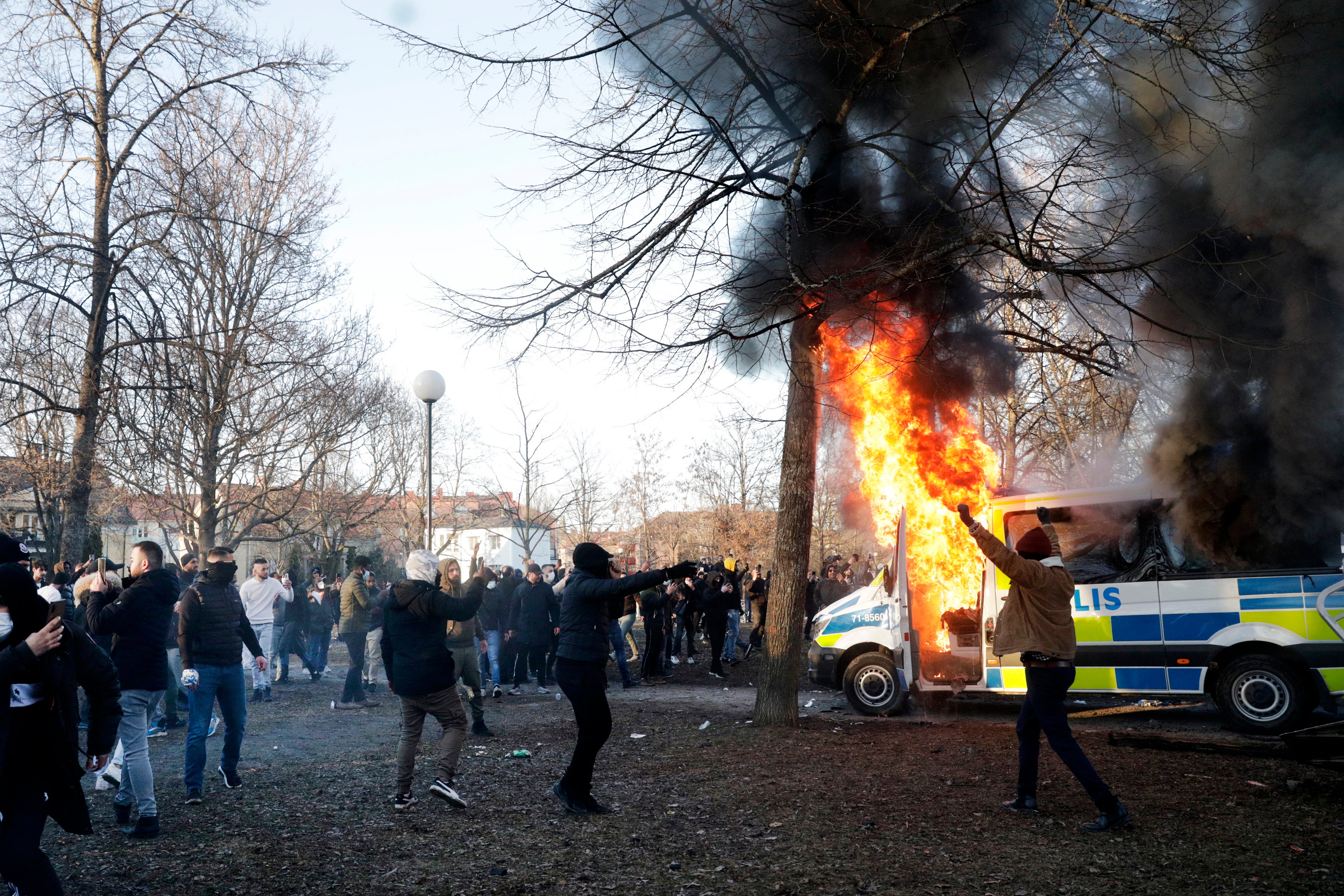 Protesters set fire to a police bus in the park Sveaparken in the riots