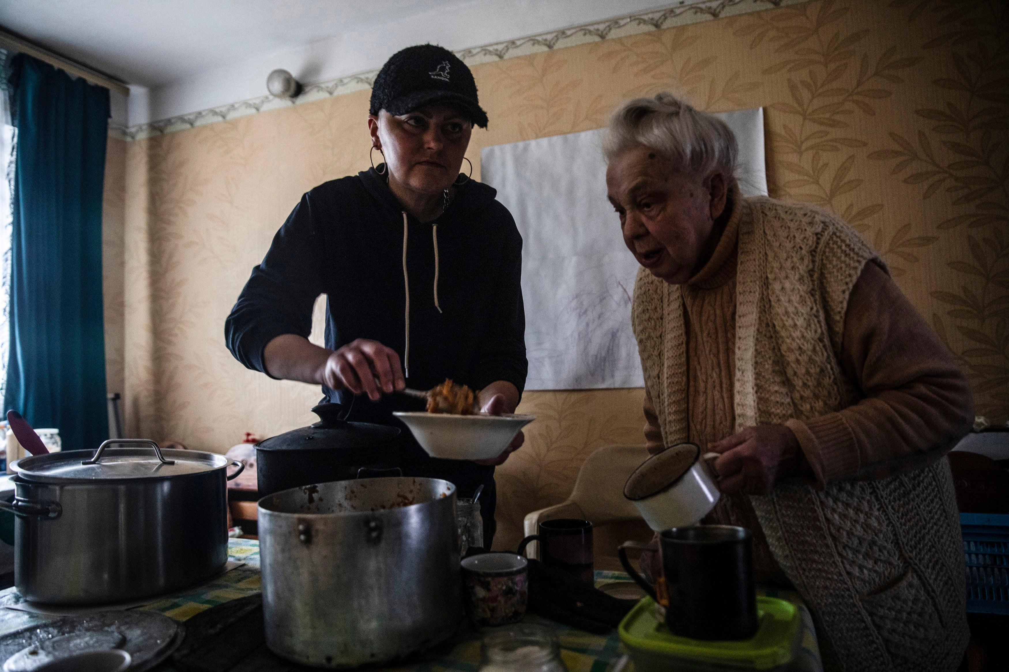 Julia Gunko spoons out stuffed cabbage for Vera Meknek, 87, one of about 50 displaced people staying in a church in Vorzel