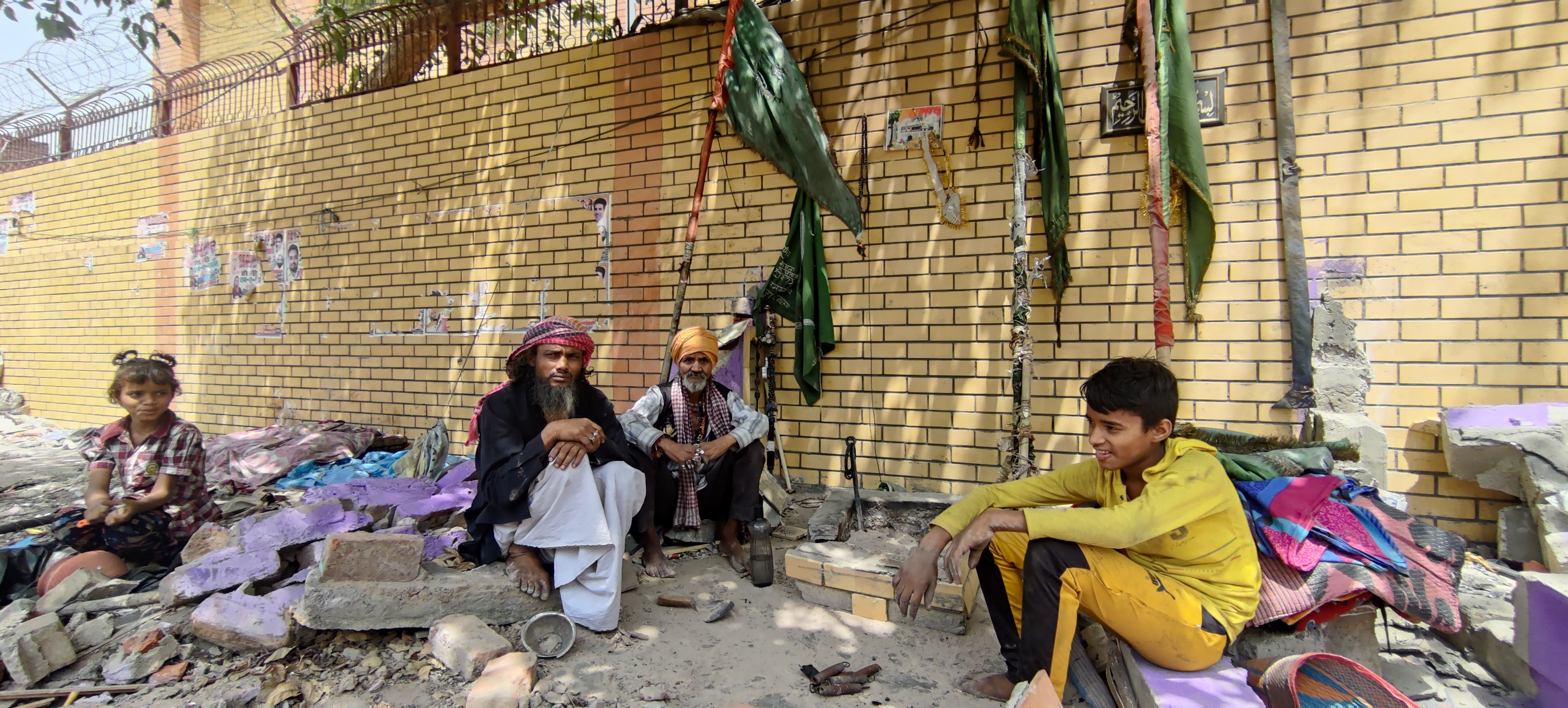 A Muslim and a Hindu ascetic sit atop the remains of a shrine that was demolished in Jahangirpuri. The two said it was a site for worship for both Hindus and Muslims, signifying their brotherhood