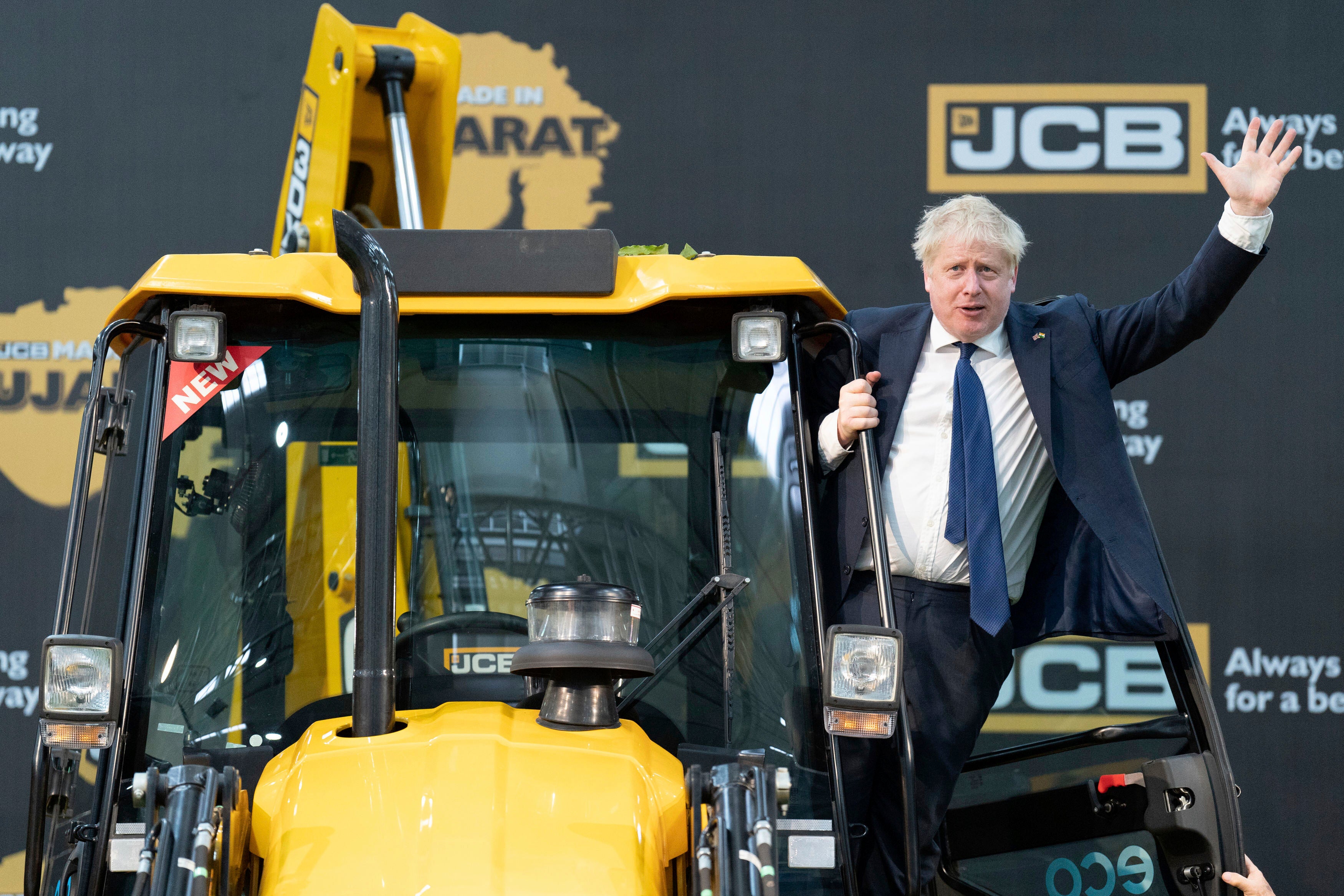 Boris Johnson climbs onto a JCB at the company’s new factory in Vadodara