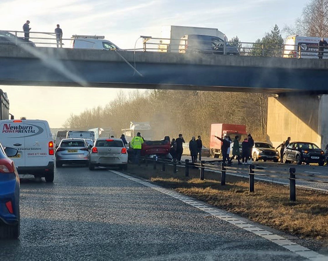 A man who left his female passenger with horrific injuries when he crashed a stolen car off a bridge on to a busy motorway has been jailed for almost three years (PA)