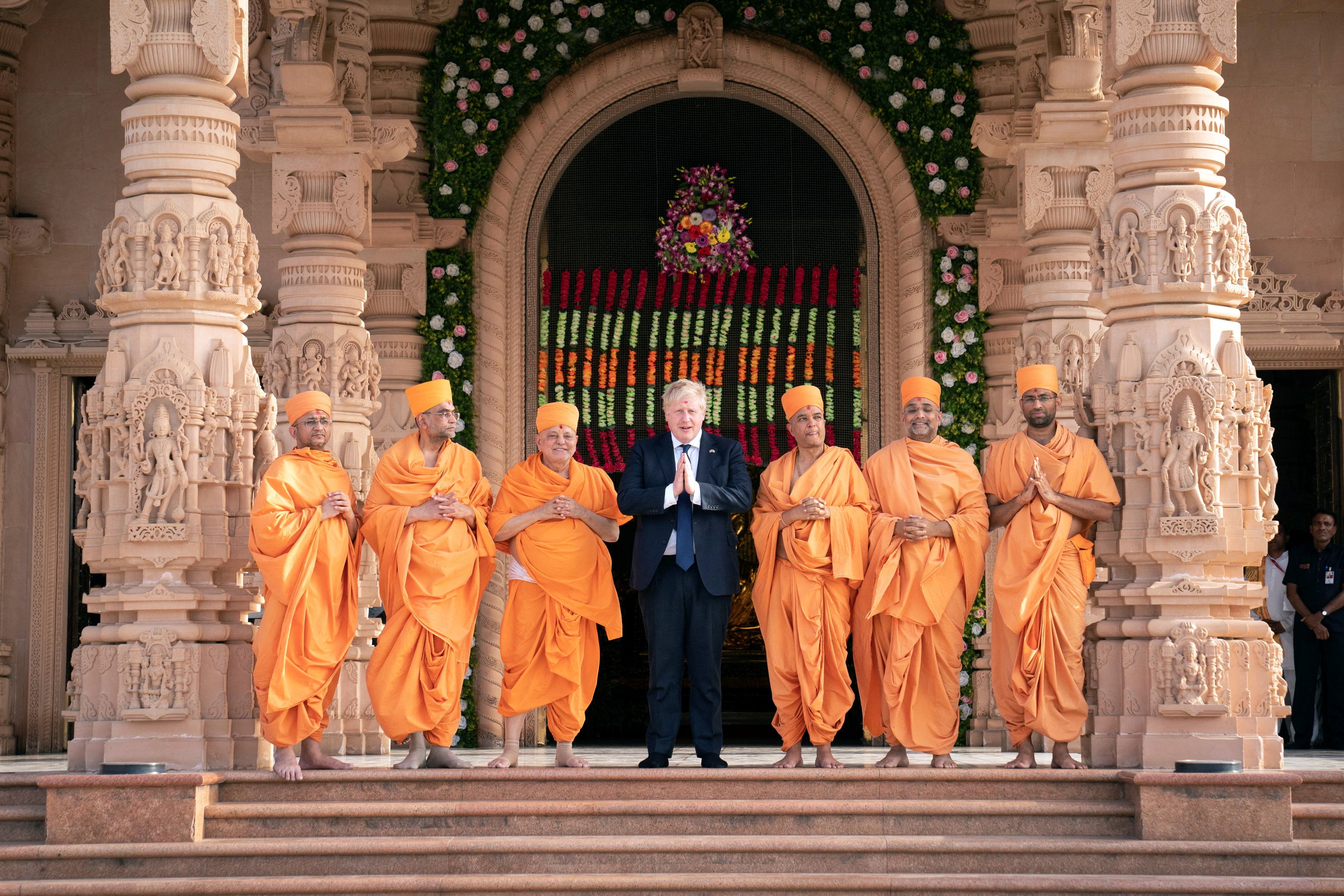 Boris Johnson poses for a picture with sadhus during his visit at the Swaminarayan Akshardham temple in Gandhinagar