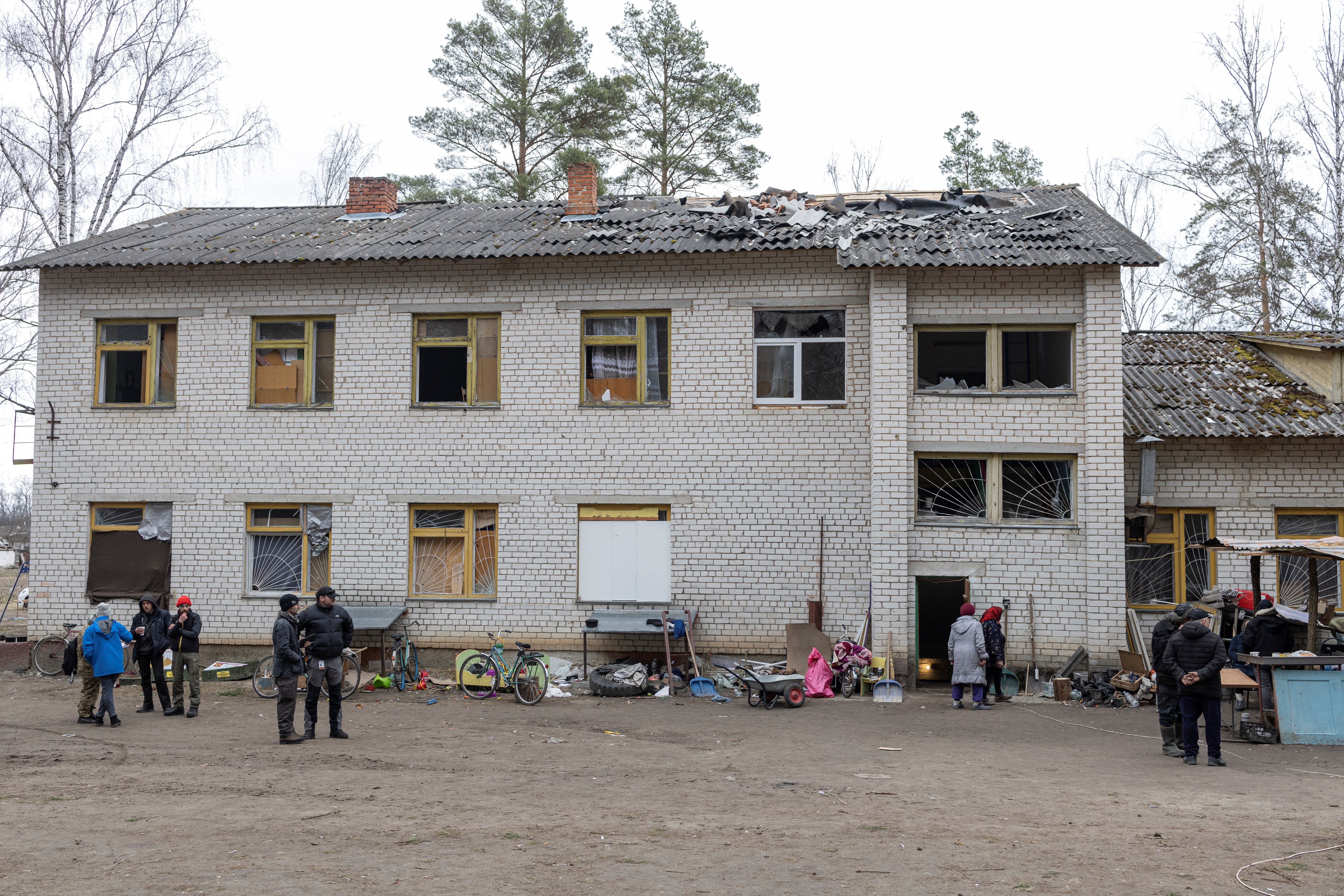 People stand in front of the damaged school