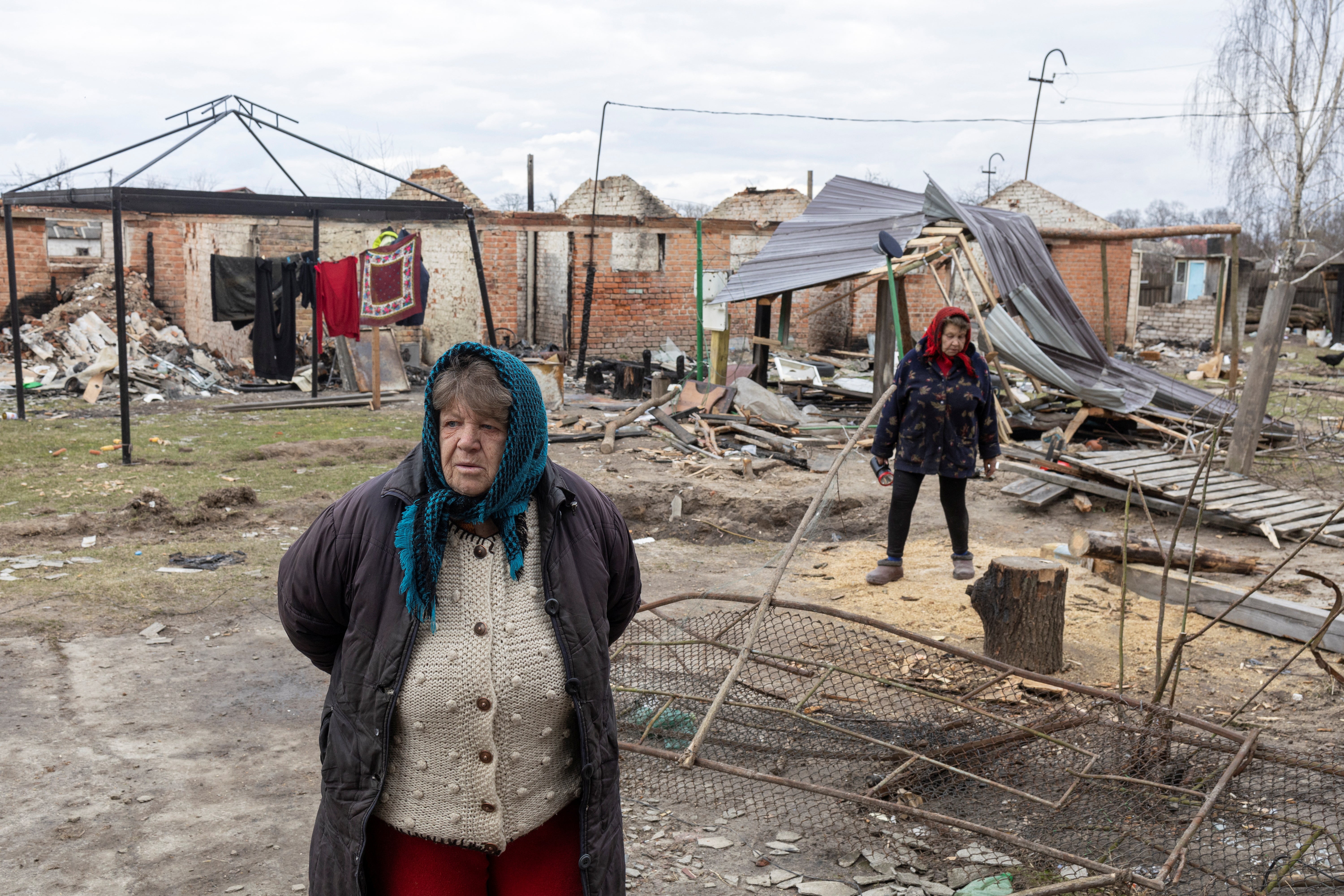 Hanna Khlystun stands amongst destroyed houses