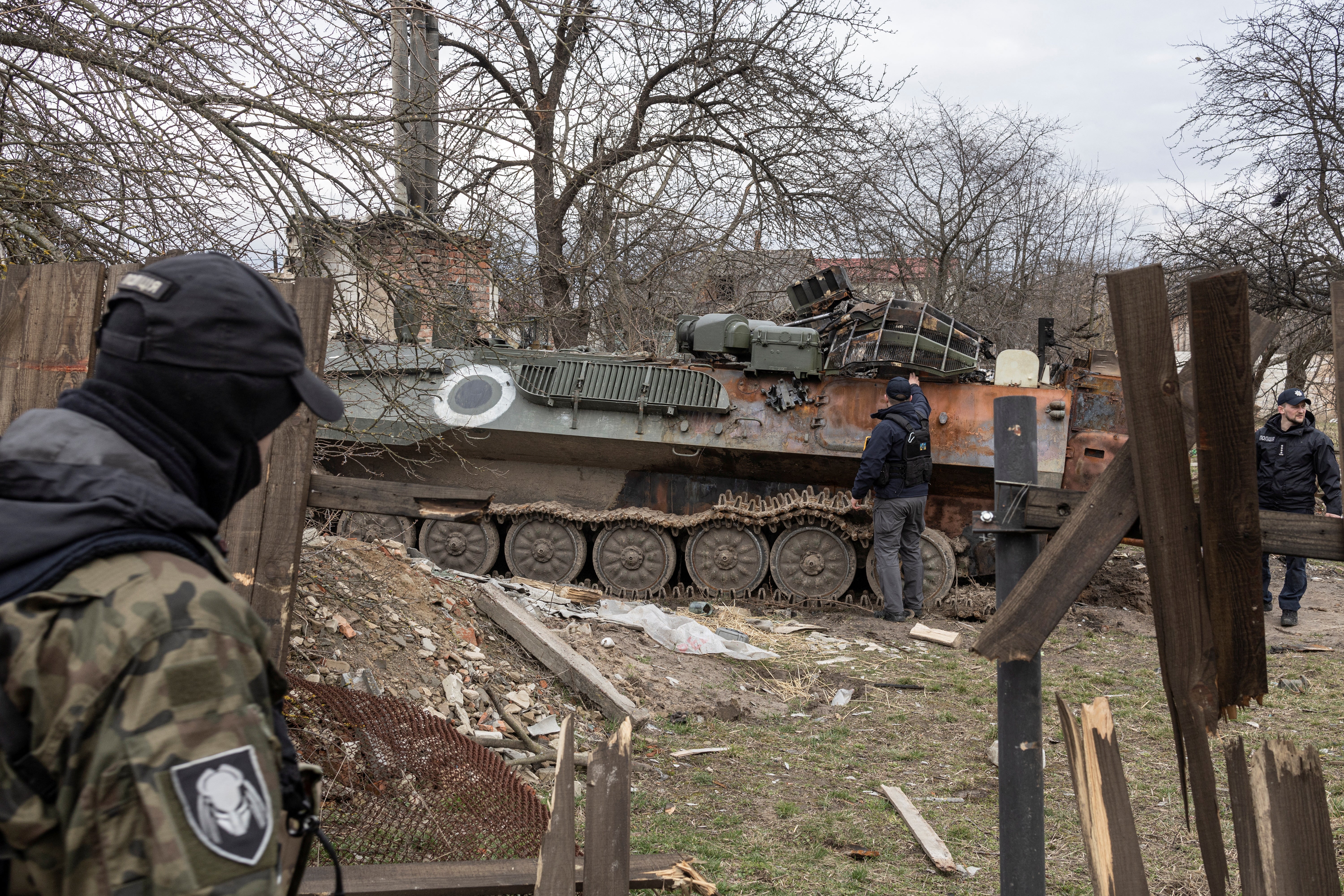 Ukrainian servicemen check a damaged Russian military vehicle