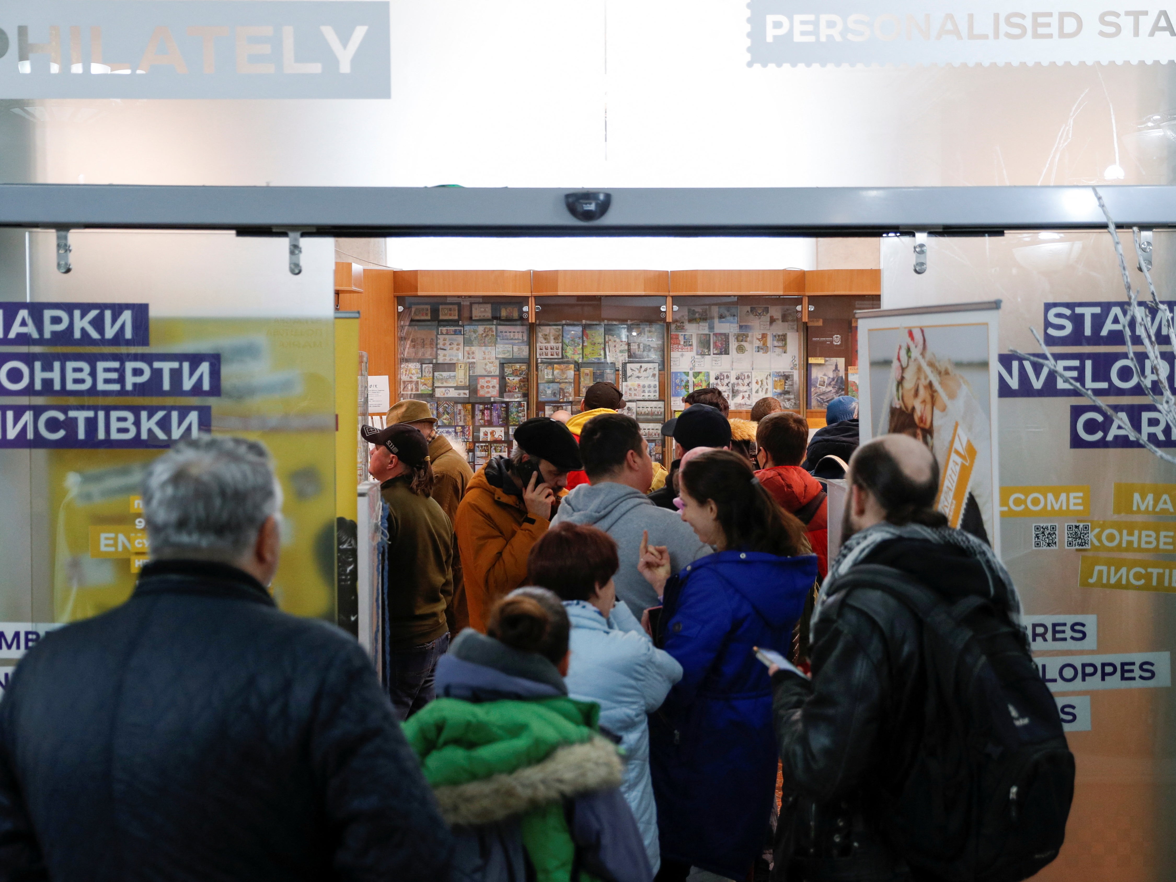 People stand in line to buy postal stamps