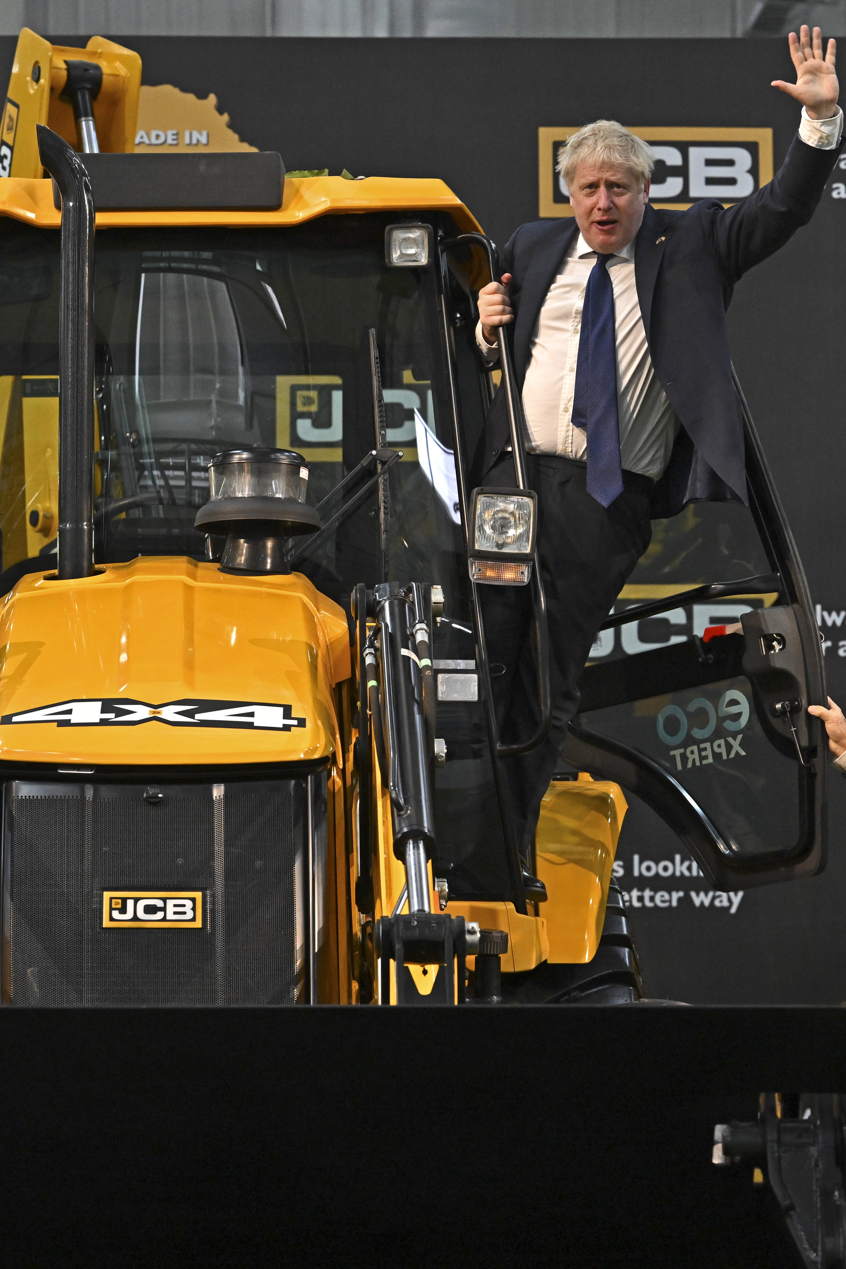 Prime Minister Boris Johnson waves from a JCB at the new JCB Factory in Vadodara, Gujarat, during his two day trip to India (Ben Stansall/PA)