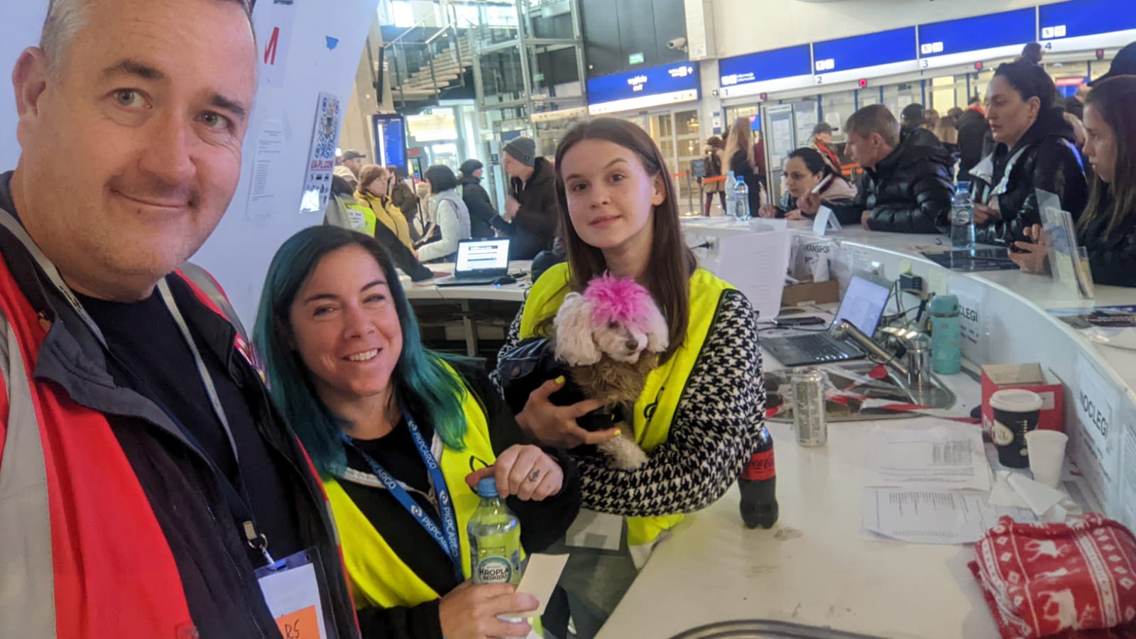 Helpers at Warsaw Central train station pose for a photo with Juno the dog (Lars Whelan)