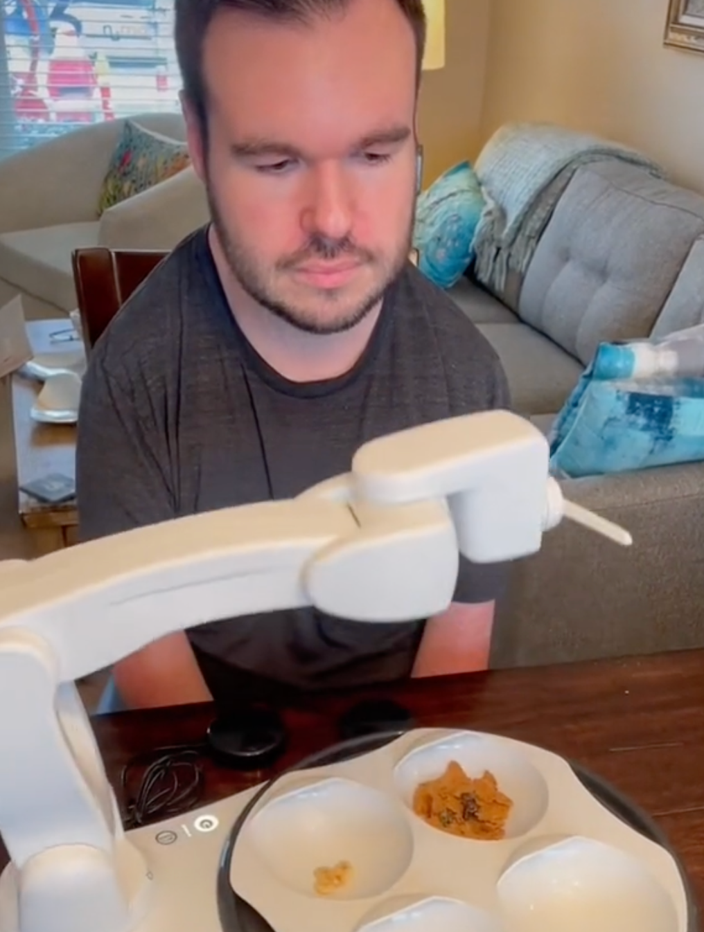 Kevin Sullivan, who is disabled, eats with the help of an Obi robotic feeder