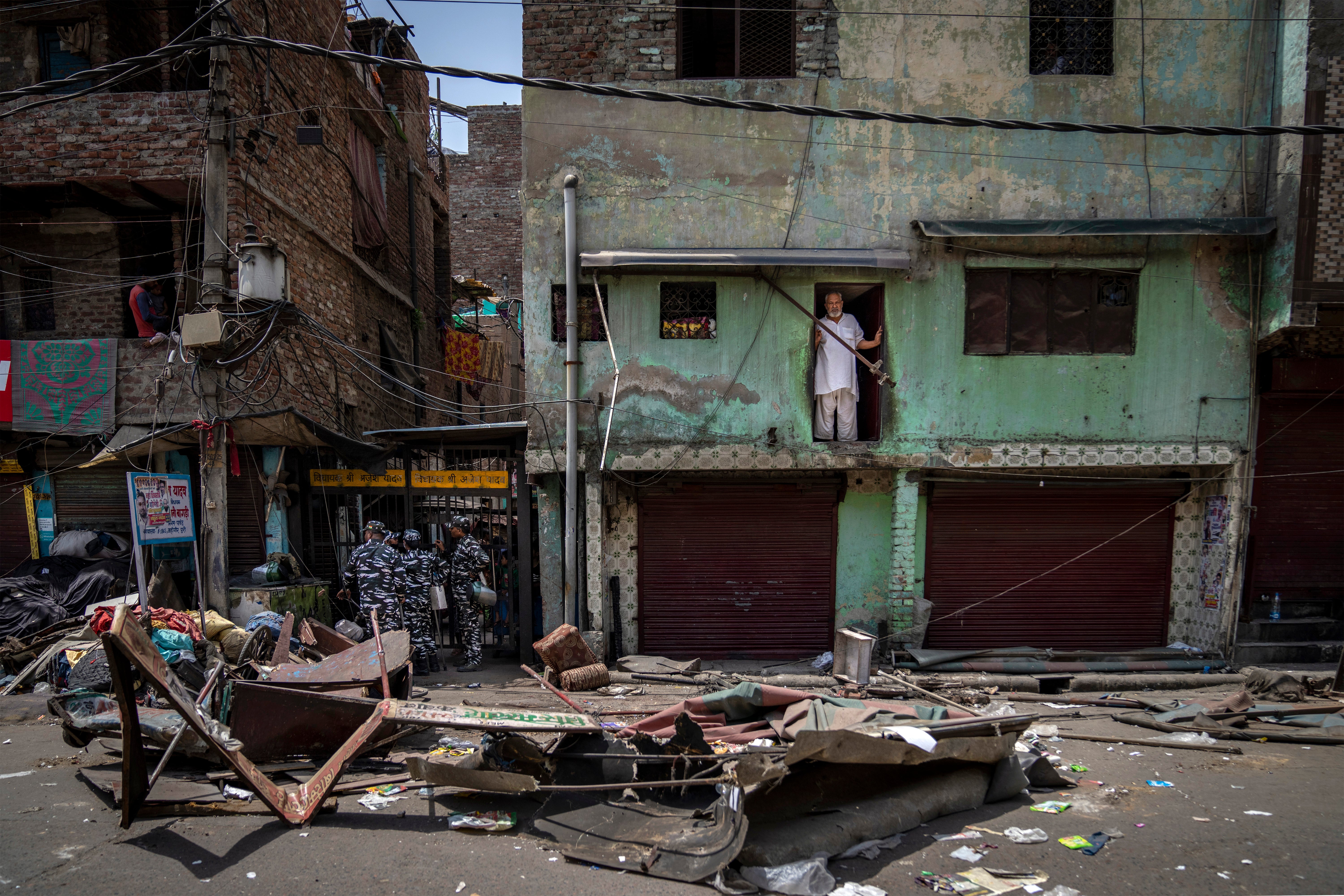 File. Muslim man watches from his house after a shop is demolished following sectarian violence in New Delhi's Jahangirpuri area on 20 April 2022