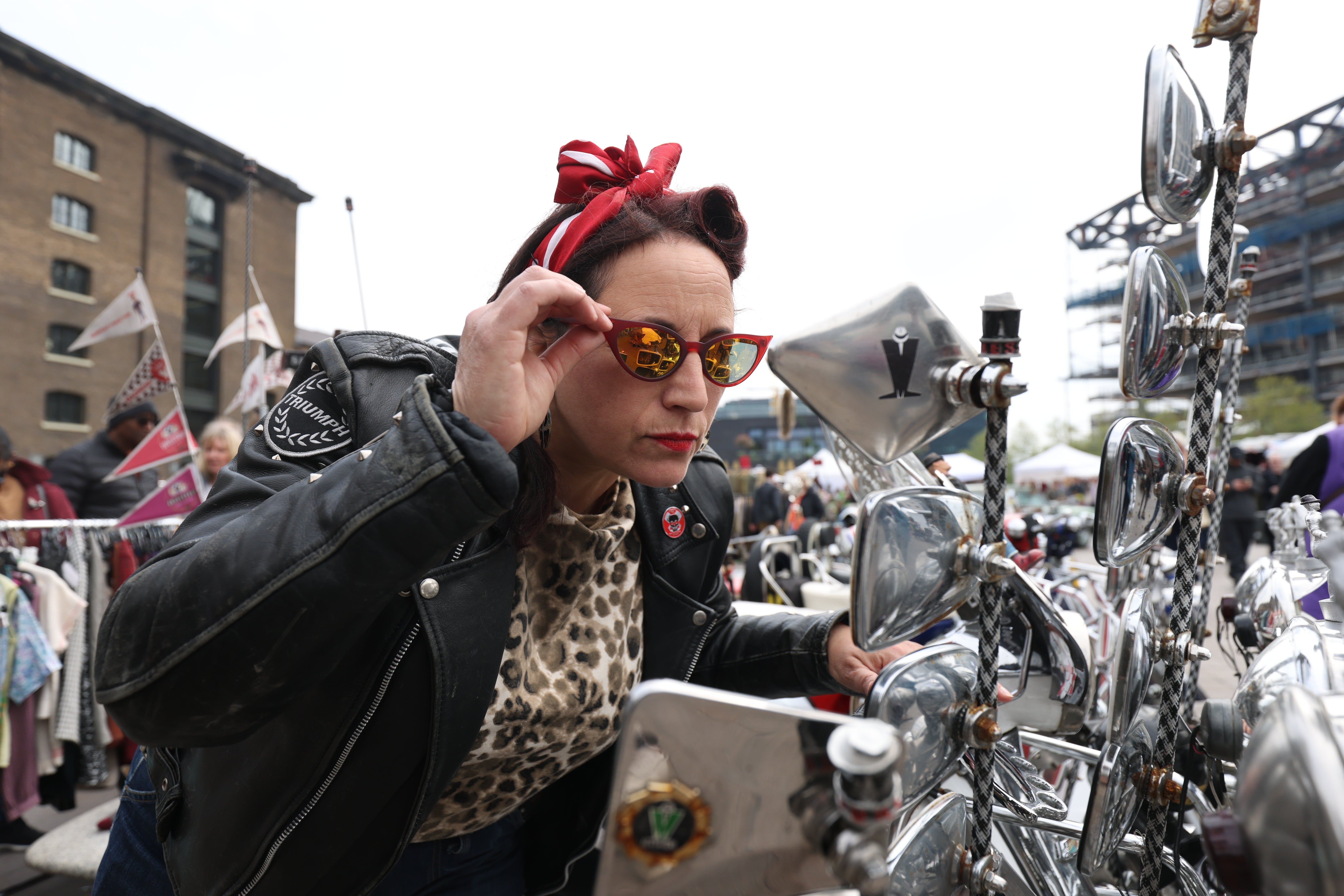 Event organiser Luigia Minichiello adjusts her glasses in the wing mirror of a Lambretta (James Manning/PA)